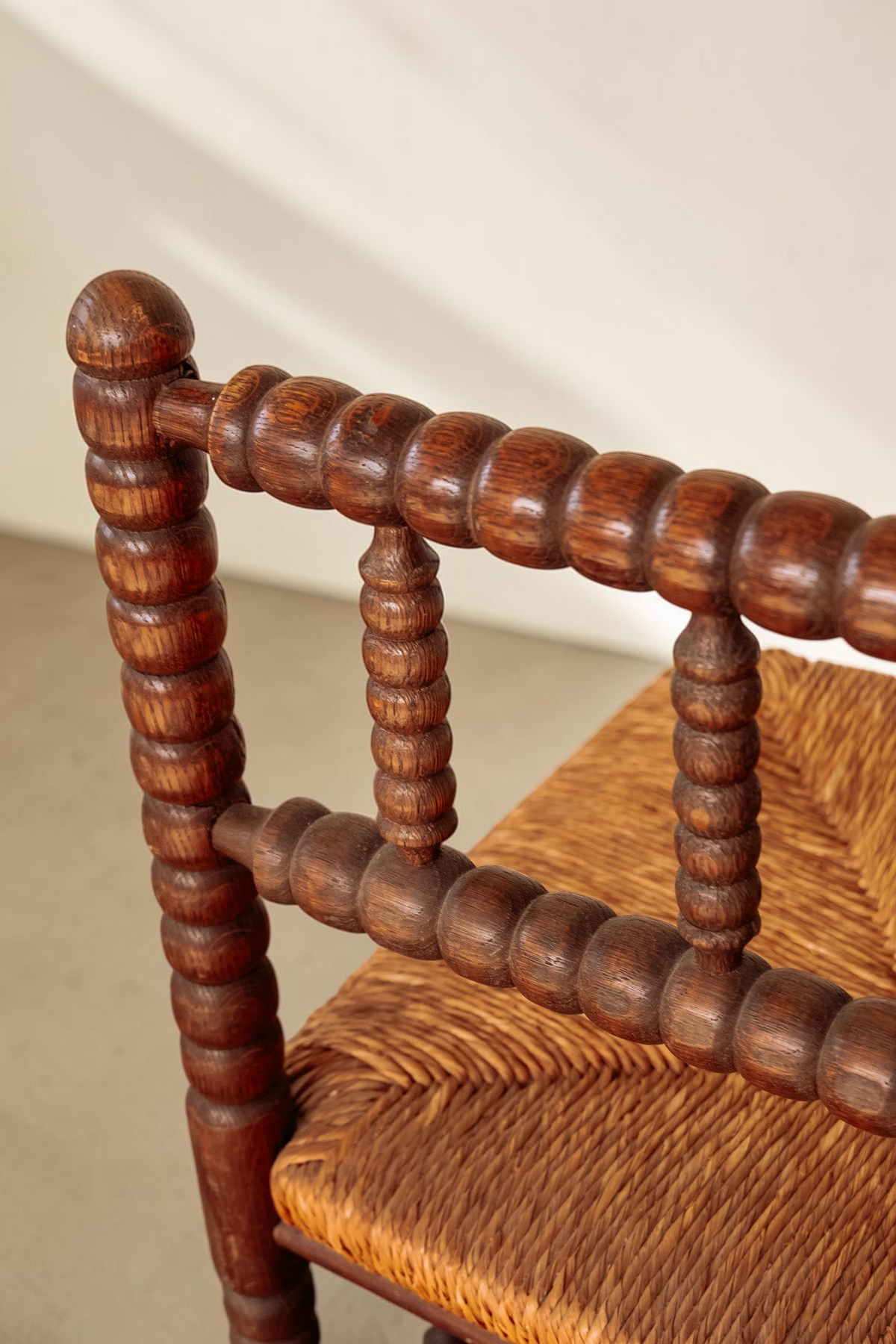 tessvintage vintage bobbin hoekstoel van massief hout met een gevlochten rieten zitting en gedraaide details