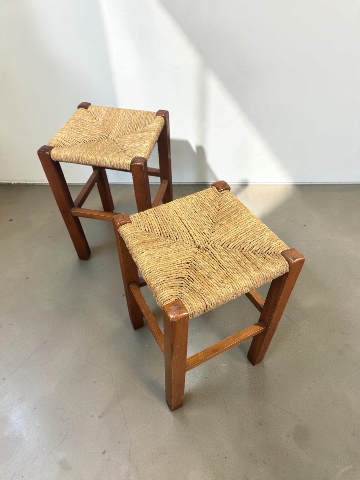 tessvintage set van twee vintage houten krukjes met een gevlochten biezen zitting in een visgraatpatroon