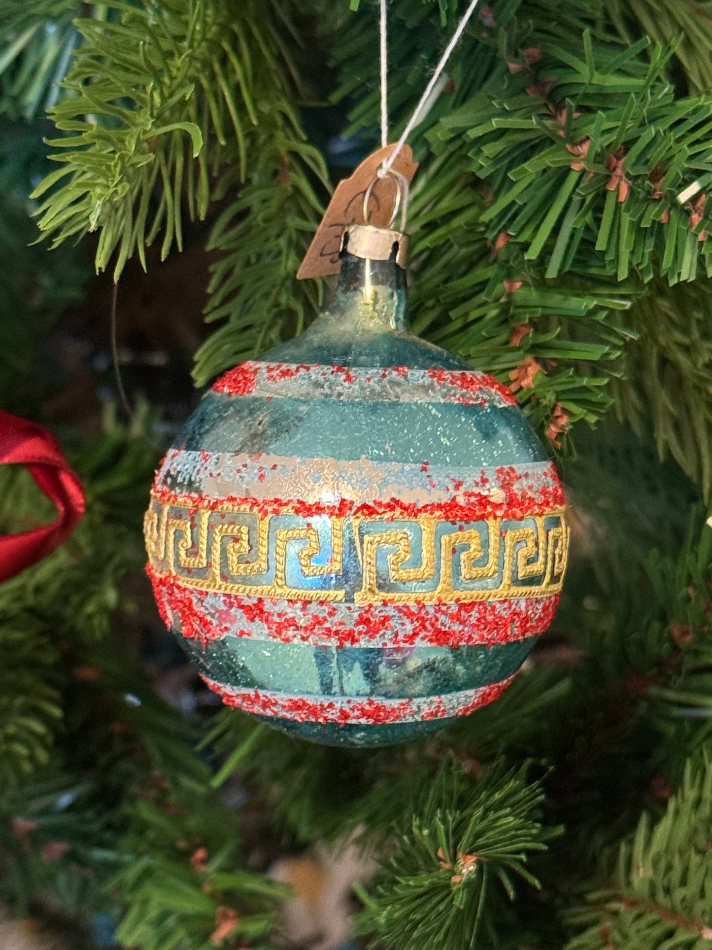 Vintage blauwe glazen kerstbal met rood gesuikerde details