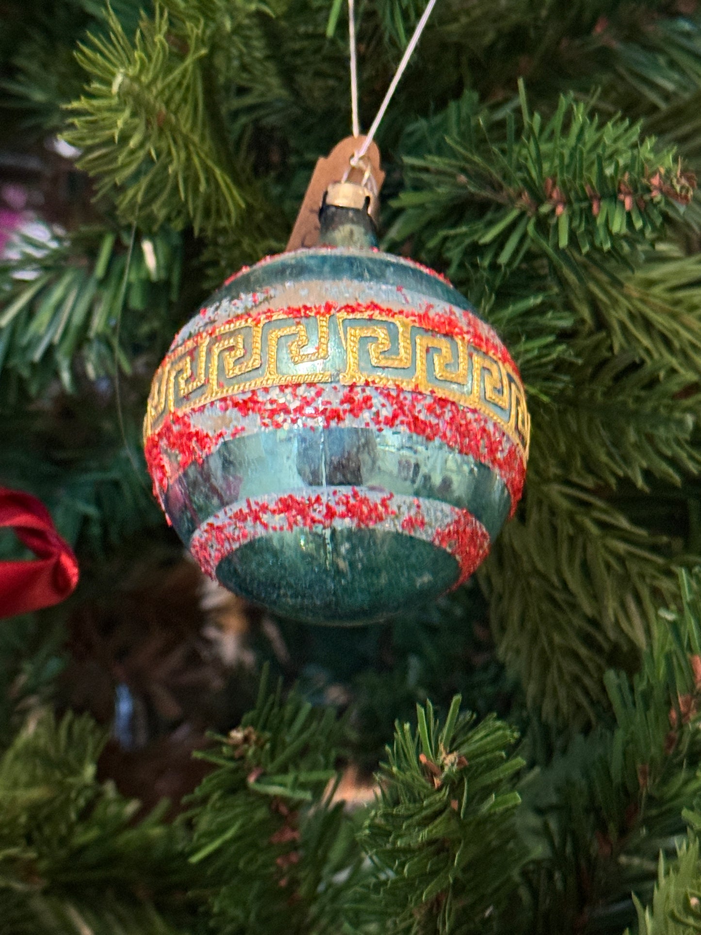 Vintage blauwe glazen kerstbal met rood gesuikerde details