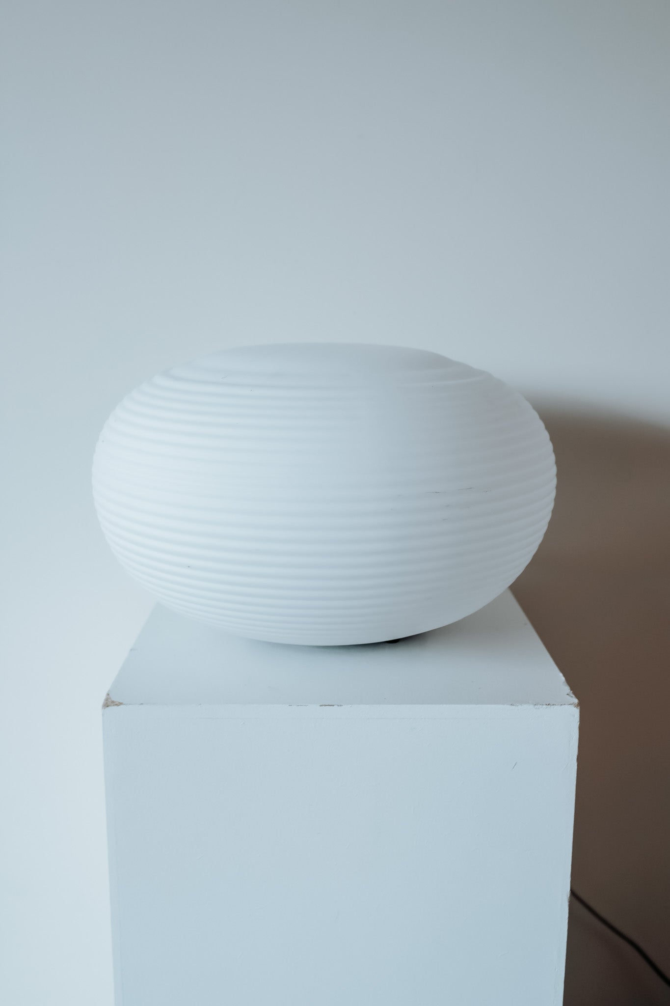 Ronde glazen tafellamp van wit geribbeld melkglas