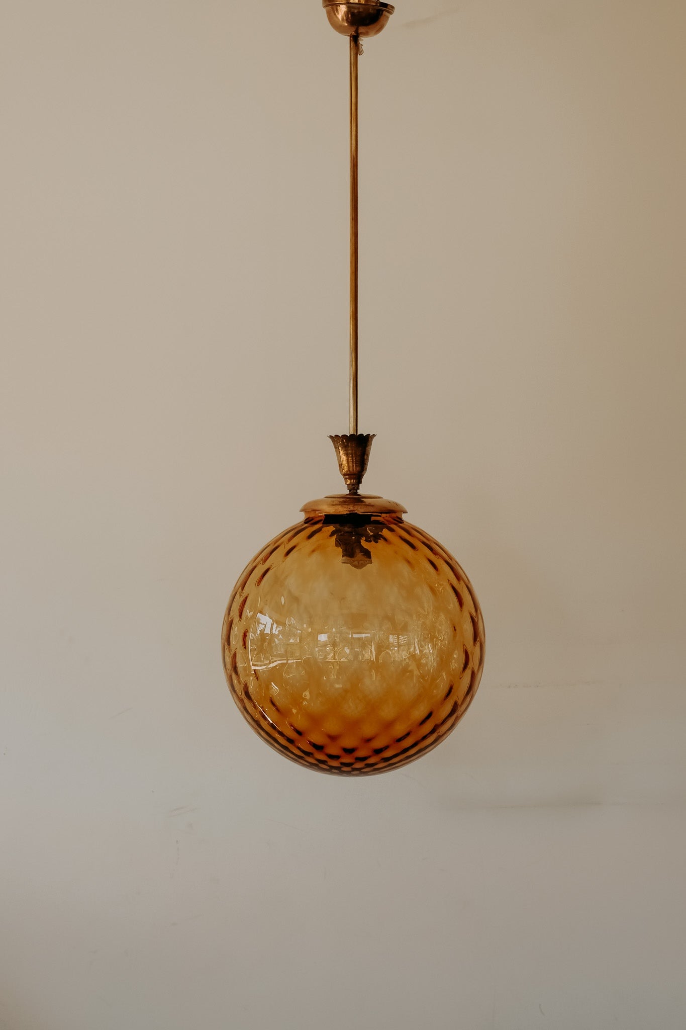 Messing hanglamp met ronde oranje glazen kap en swirl structuur