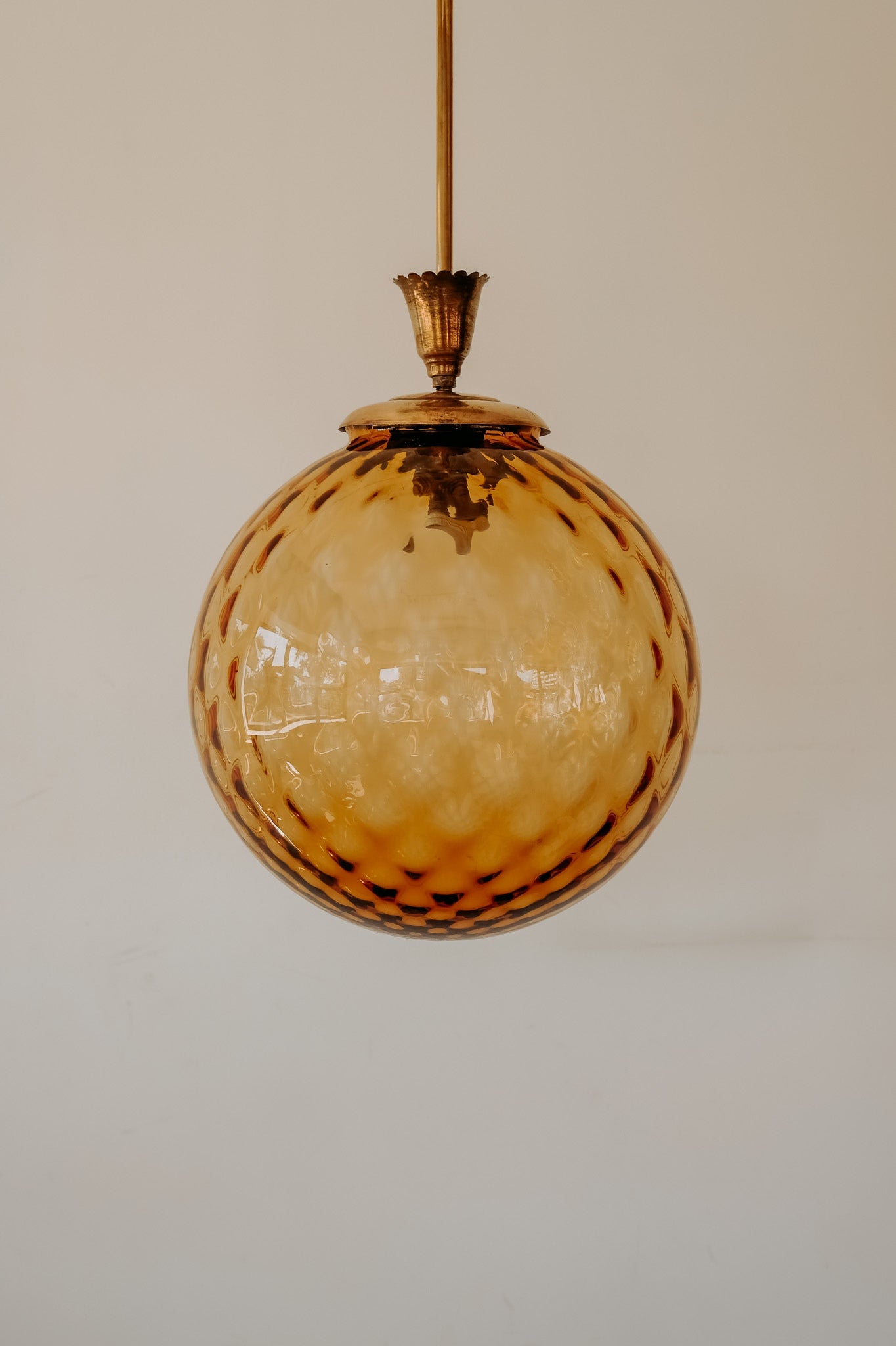 Messing hanglamp met ronde oranje glazen kap en swirl structuur