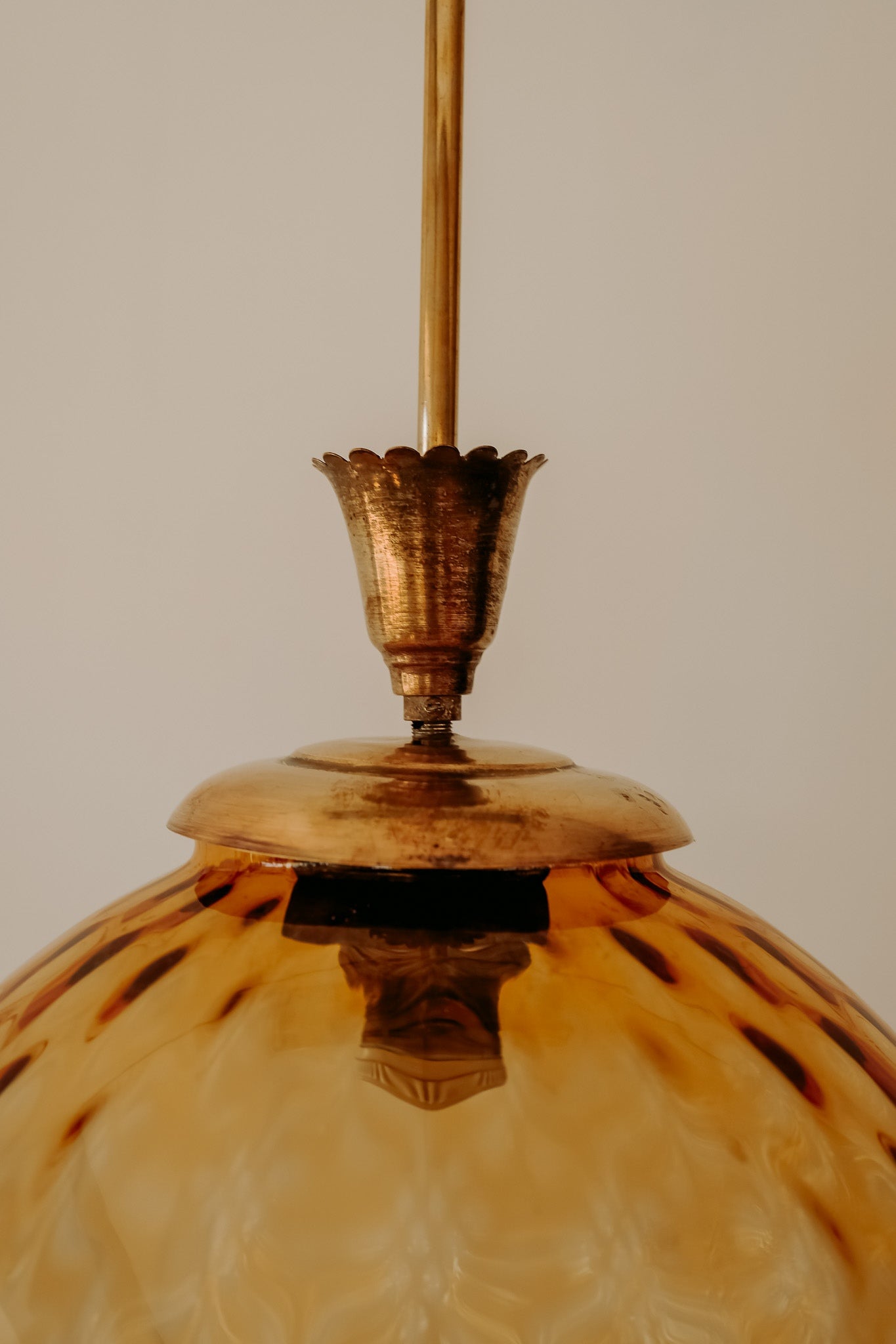 Messing hanglamp met ronde oranje glazen kap en swirl structuur