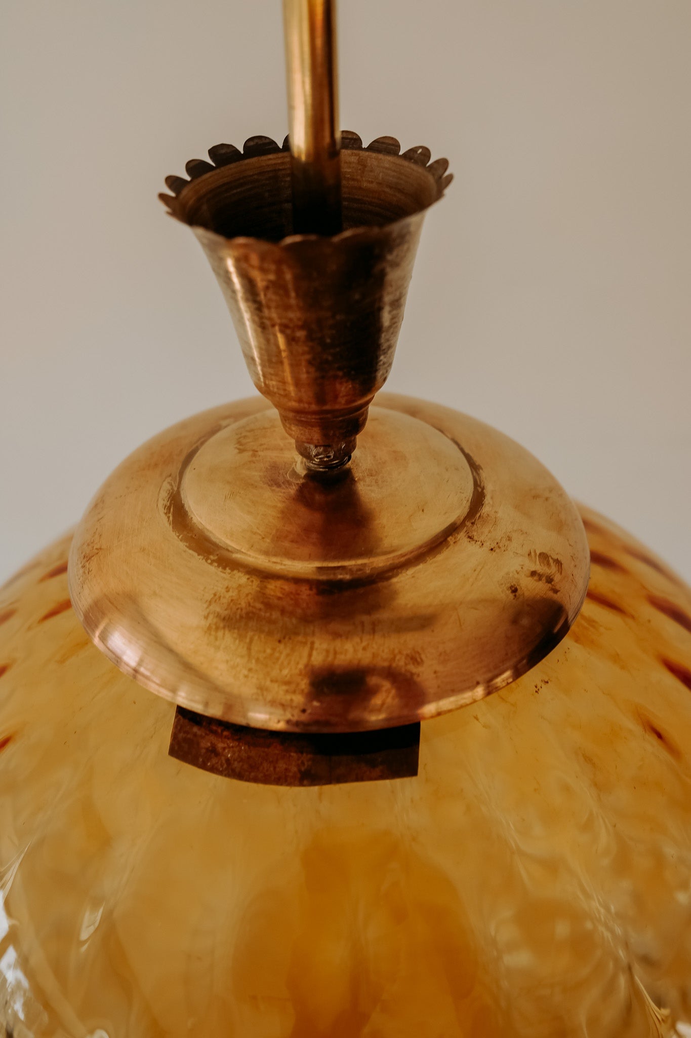 Messing hanglamp met ronde oranje glazen kap en swirl structuur