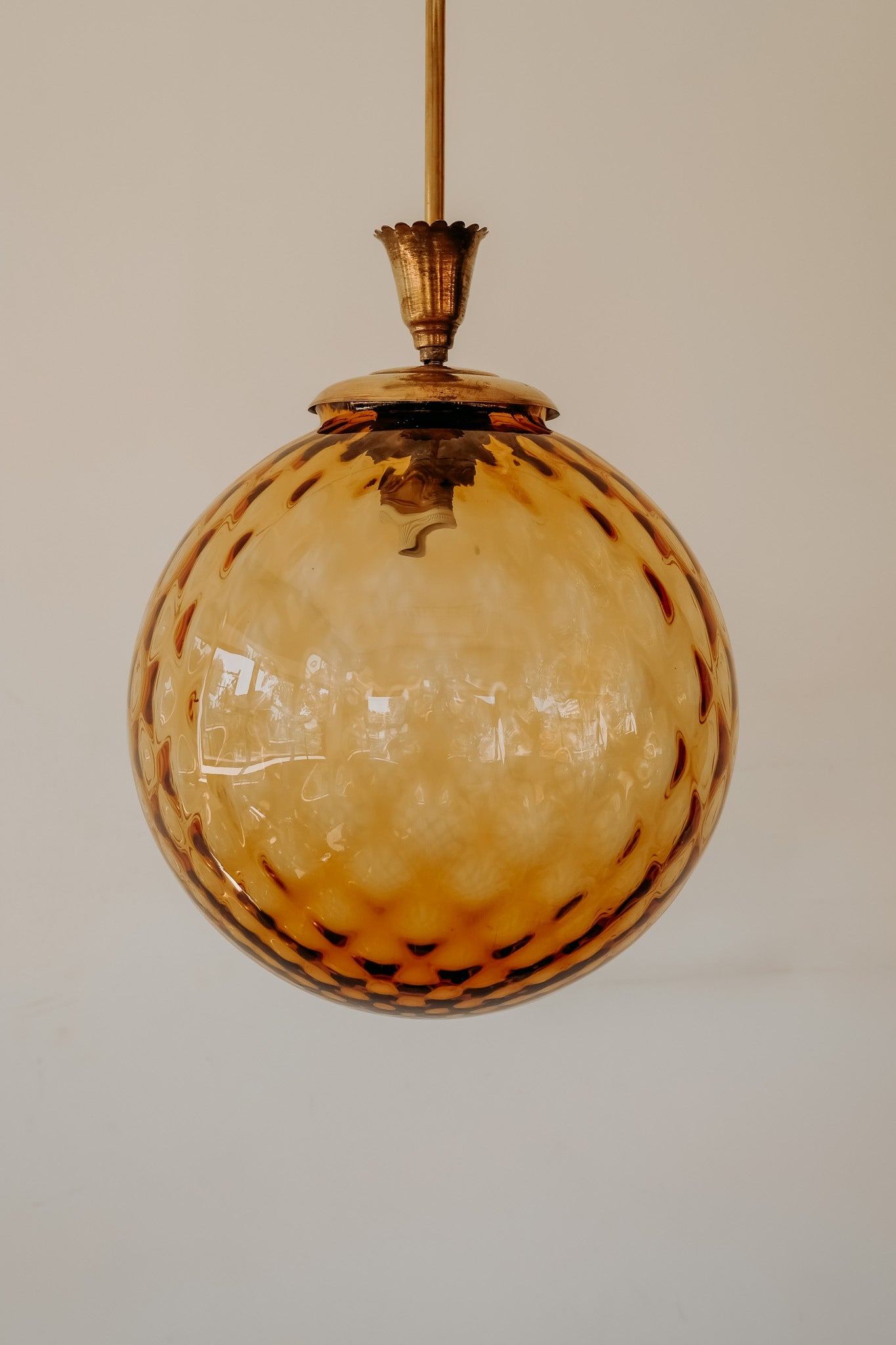 Messing hanglamp met ronde oranje glazen kap en swirl structuur