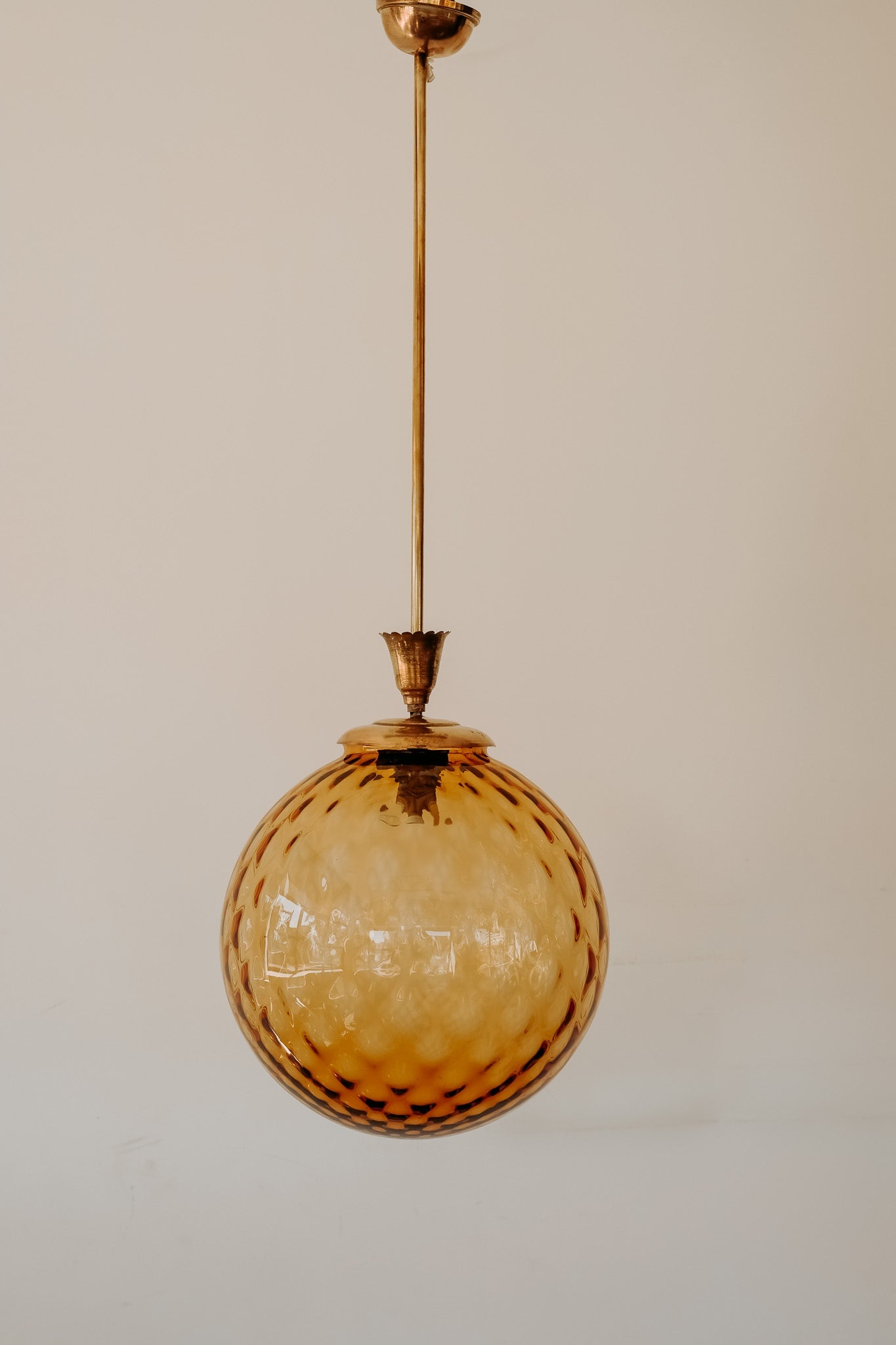 Messing hanglamp met ronde oranje glazen kap en swirl structuur