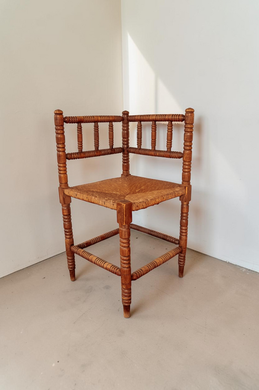 tessvintage vintage houten bobbin hoekstoel met een gevlochten rieten zitting in een klassieke stijl