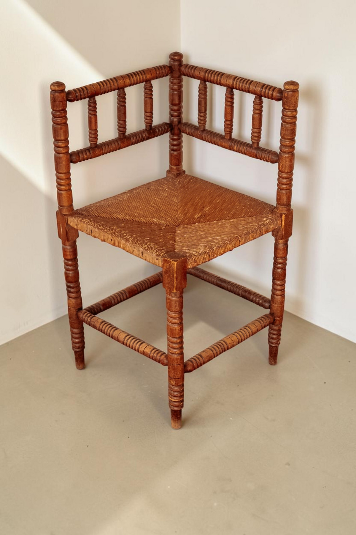 tessvintage vintage hoekstoel van massief hout met bobbin details en een gevlochten rieten zitting