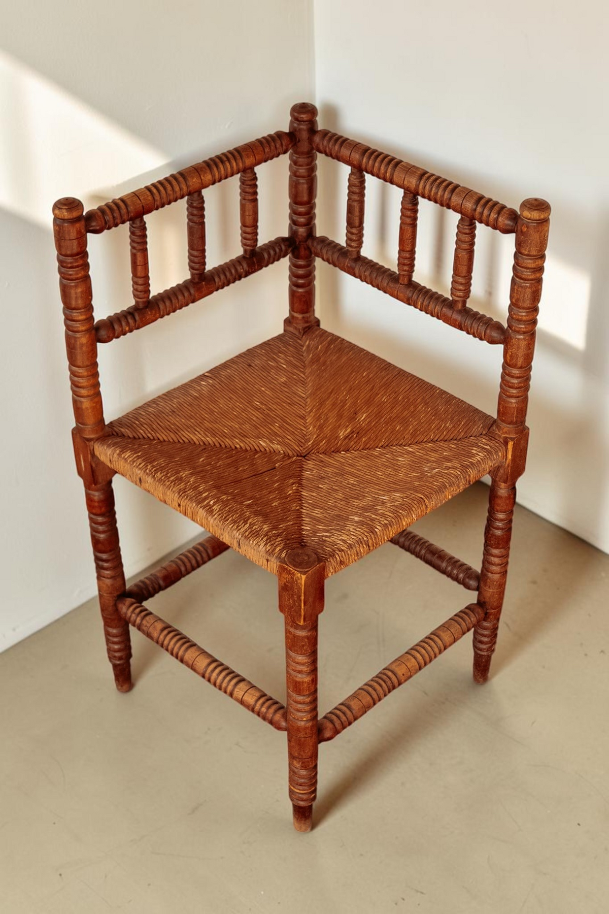tessvintage vintage hoekstoel van massief hout met gedraaide bobbin poten en een gevlochten rieten zitting