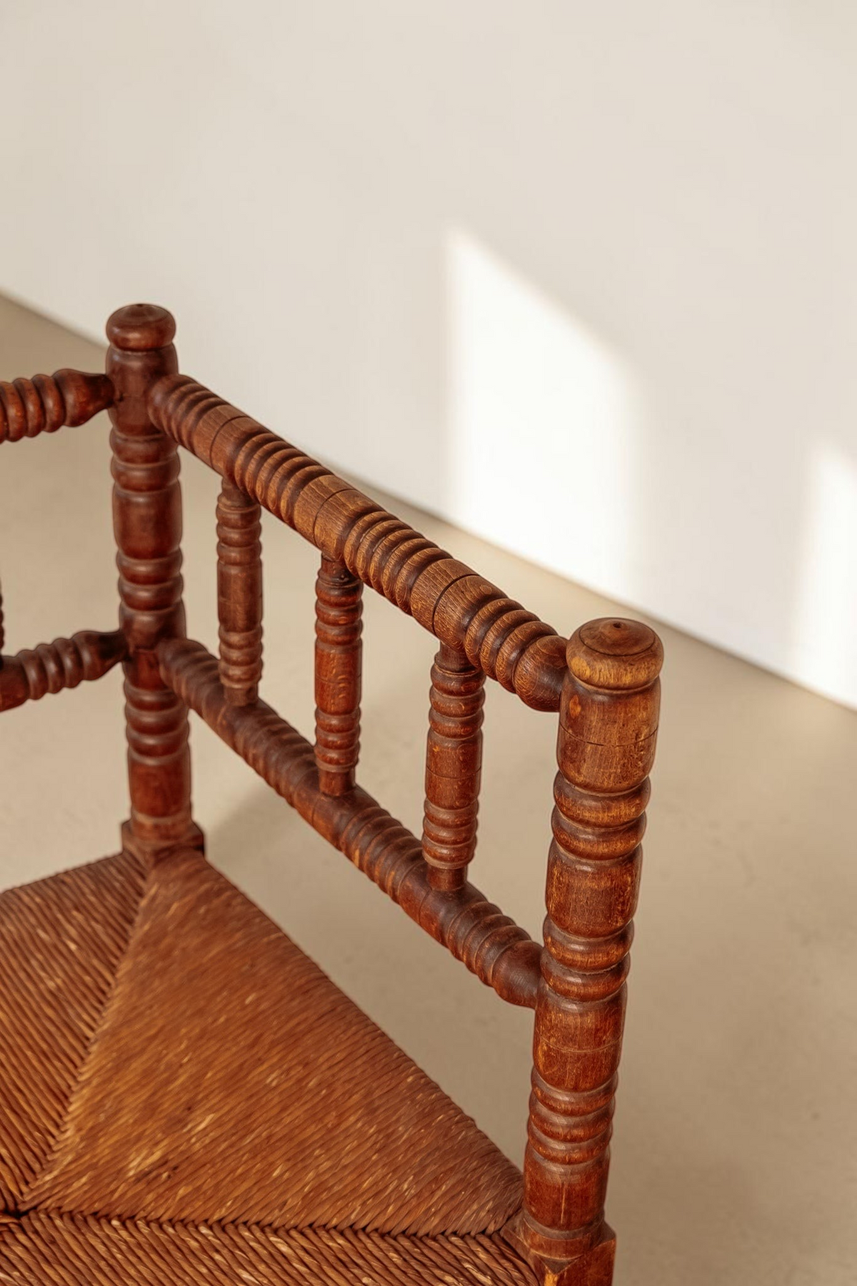 tessvintage vintage hoekstoel van massief hout met bobbin details en een gevlochten rieten zitting