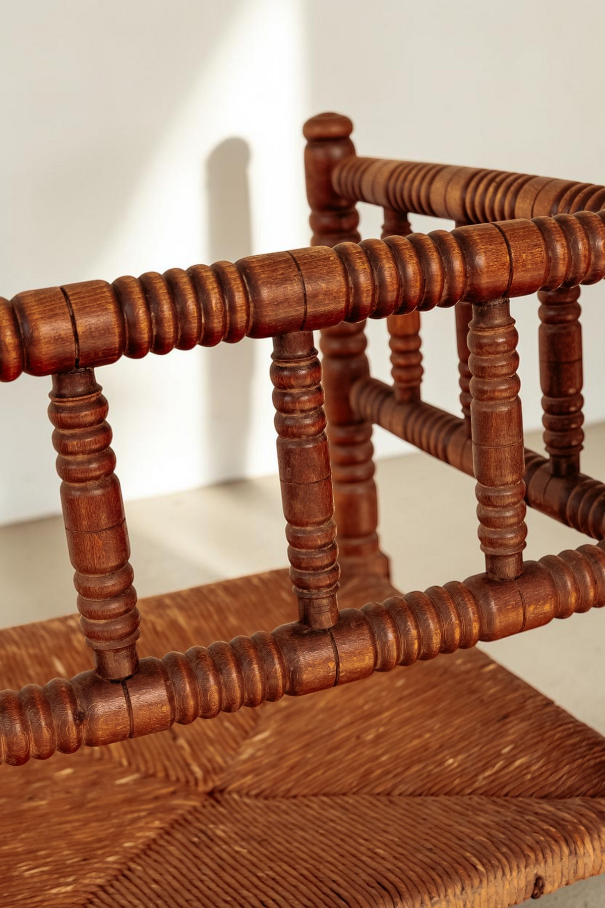 tessvintage vintage houten bobbin hoekstoel met gedetailleerde spijlen en een gevlochten rieten zitting