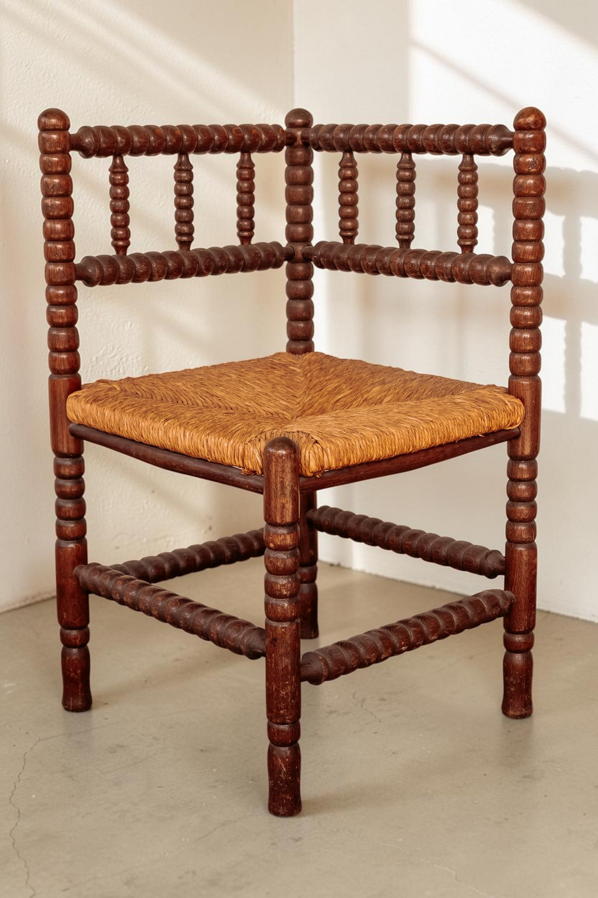 tessvintage vintage houten hoekstoel met bobbin details en een gevlochten rieten zitting