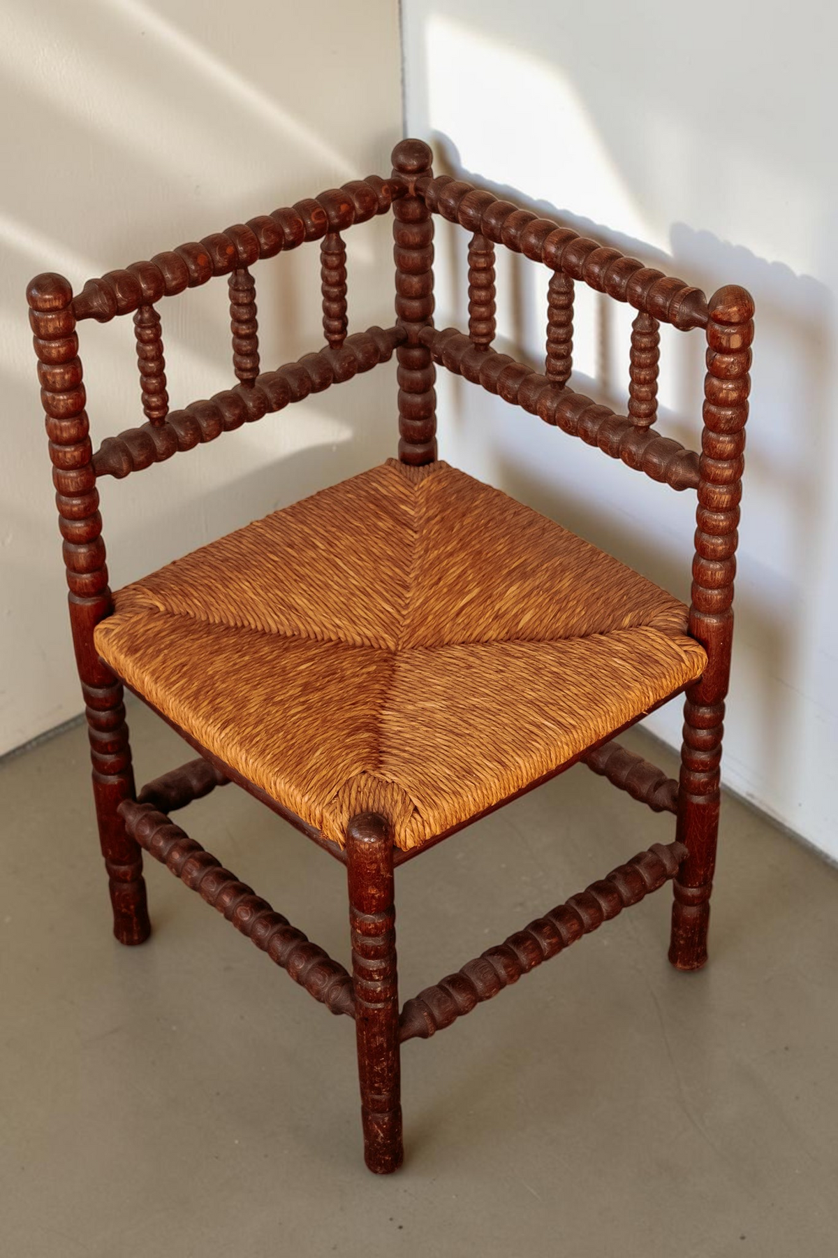 tessvintage vintage hoekstoel van massief hout met bobbin details en een gevlochten rieten zitting
