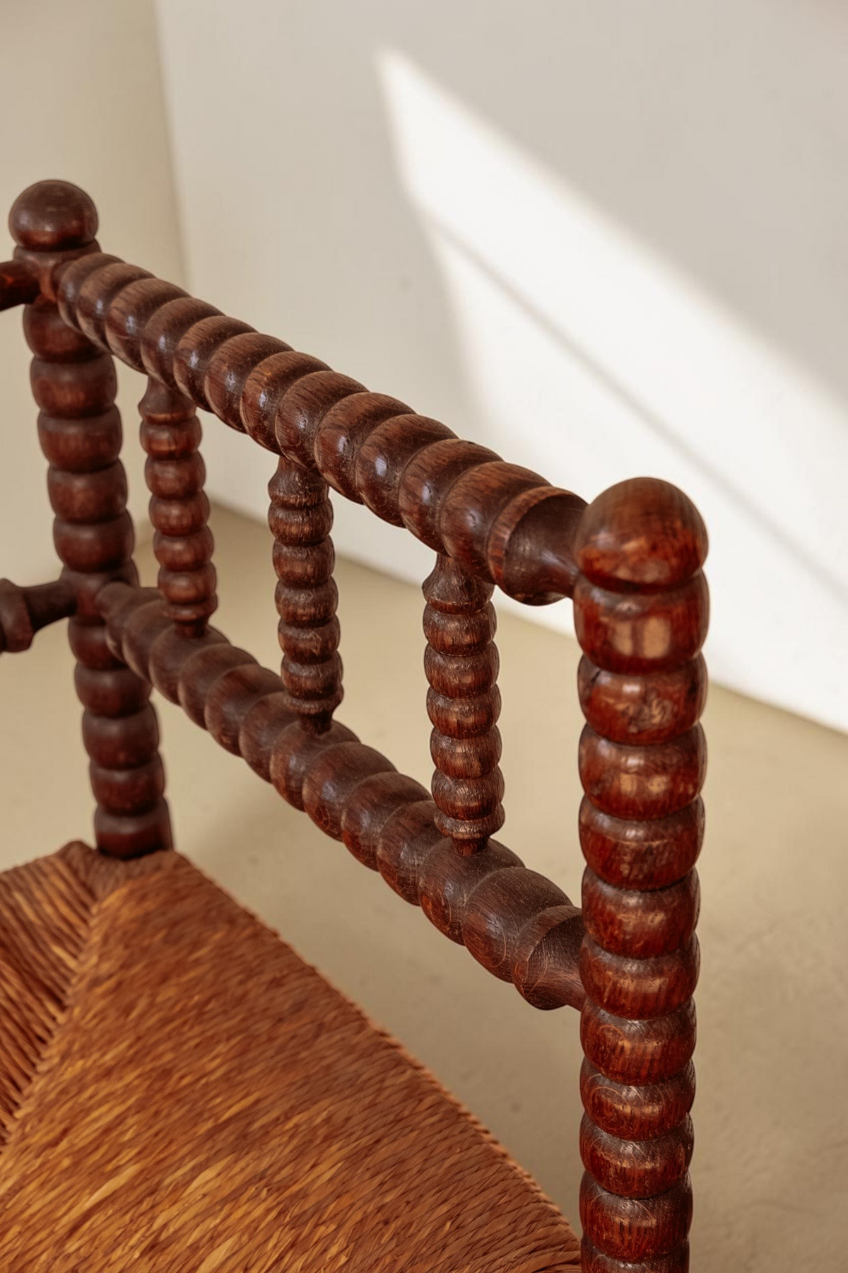 tessvintage vintage hoekstoel van massief hout met bobbin details en een gevlochten rieten zitting