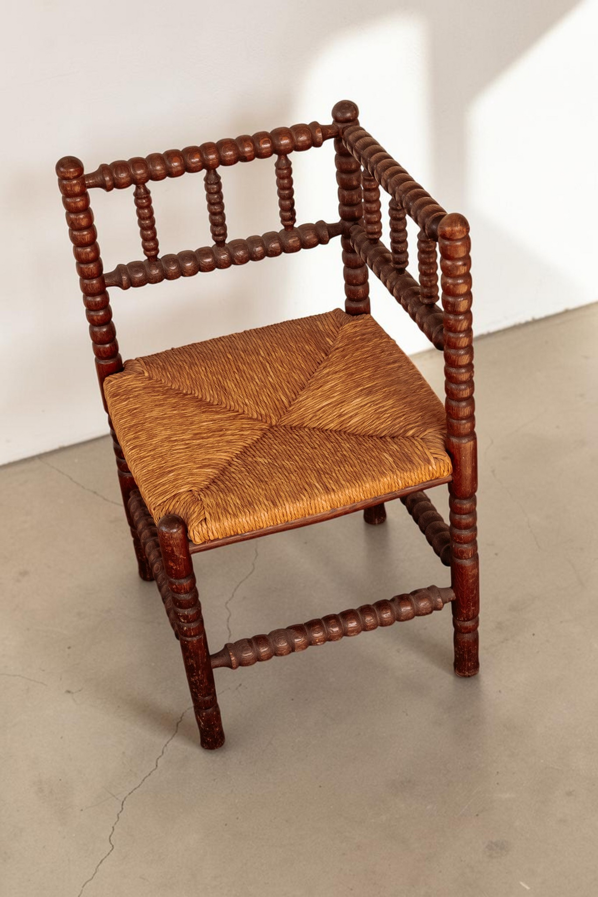 tessvintage vintage hoekstoel van massief hout met bobbin details en een gevlochten rieten zitting