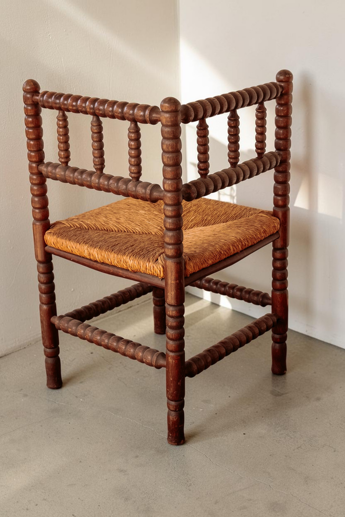 tessvintage vintage hoekstoel van massief hout met bobbin details en een gevlochten rieten zitting