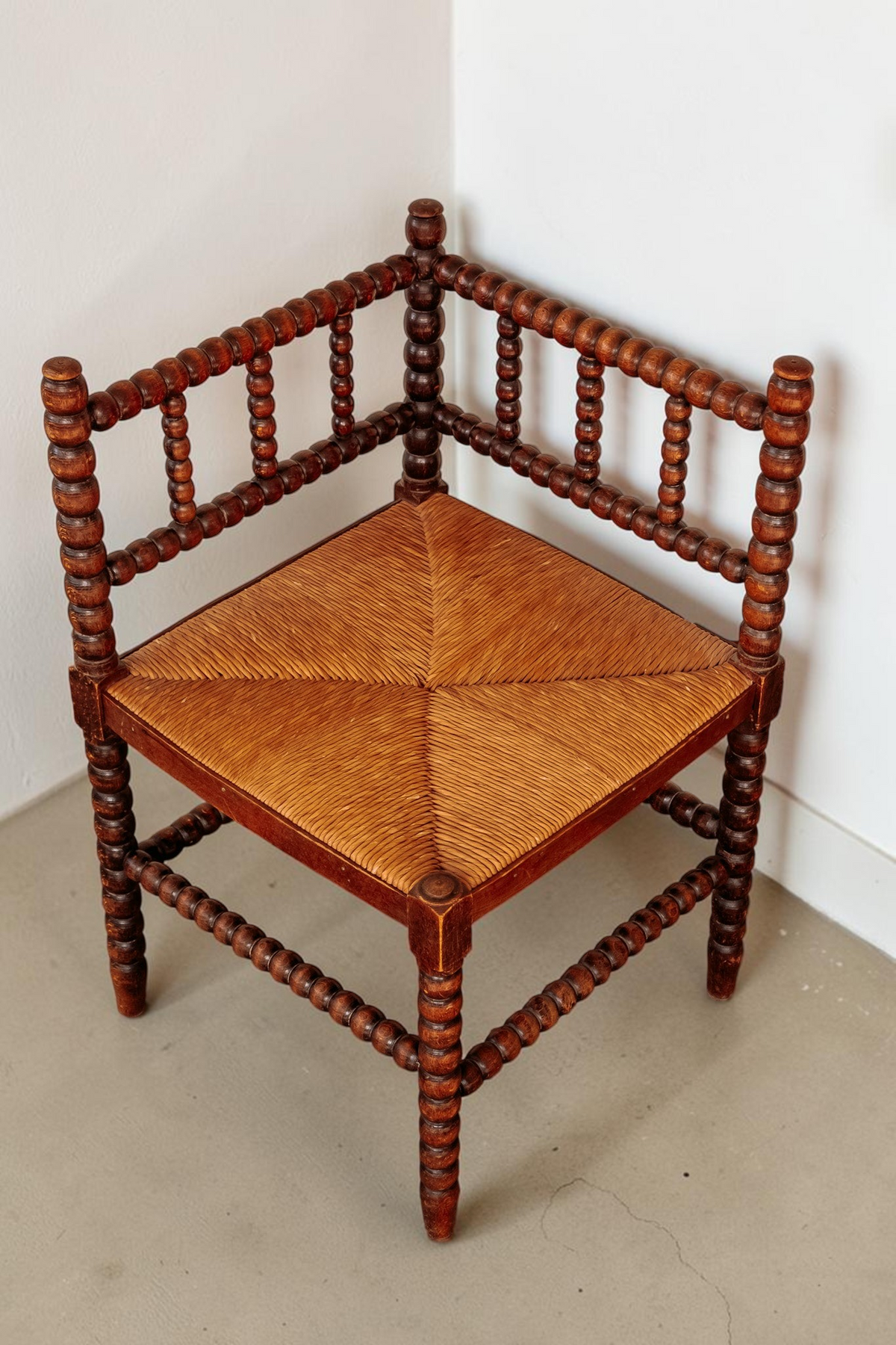 tessvintage vintage hoekstoel van massief hout met bobbin details en een gevlochten rieten zitting