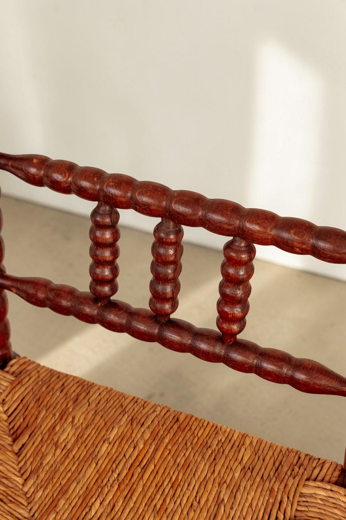 tessvintage antieke houten bobbin hoekstoel met gedetailleerde spijlen en een gevlochten rieten zitting