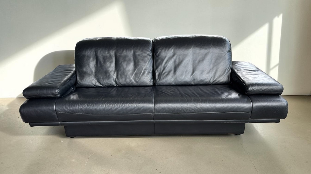 tessvintage Rolf Benz 6500 3-zitsbank in zwart leer met brede armleuningen en een robuust jaren 80 design