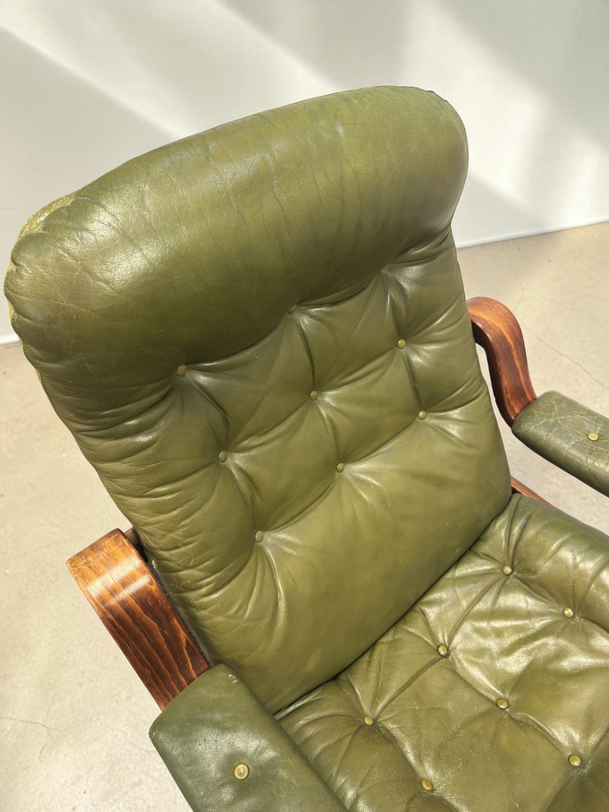 tessvintage olijfgroene vintage fauteuil van Göte Möbler met gecapitonneerd leer en gebogen houten armleuningen