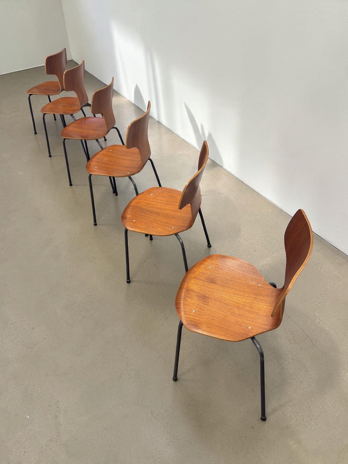 Set van zes vintage tessvintage Arne Jacobsen model 3103 T-stoelen in teakfineer met zwarte metalen poten.