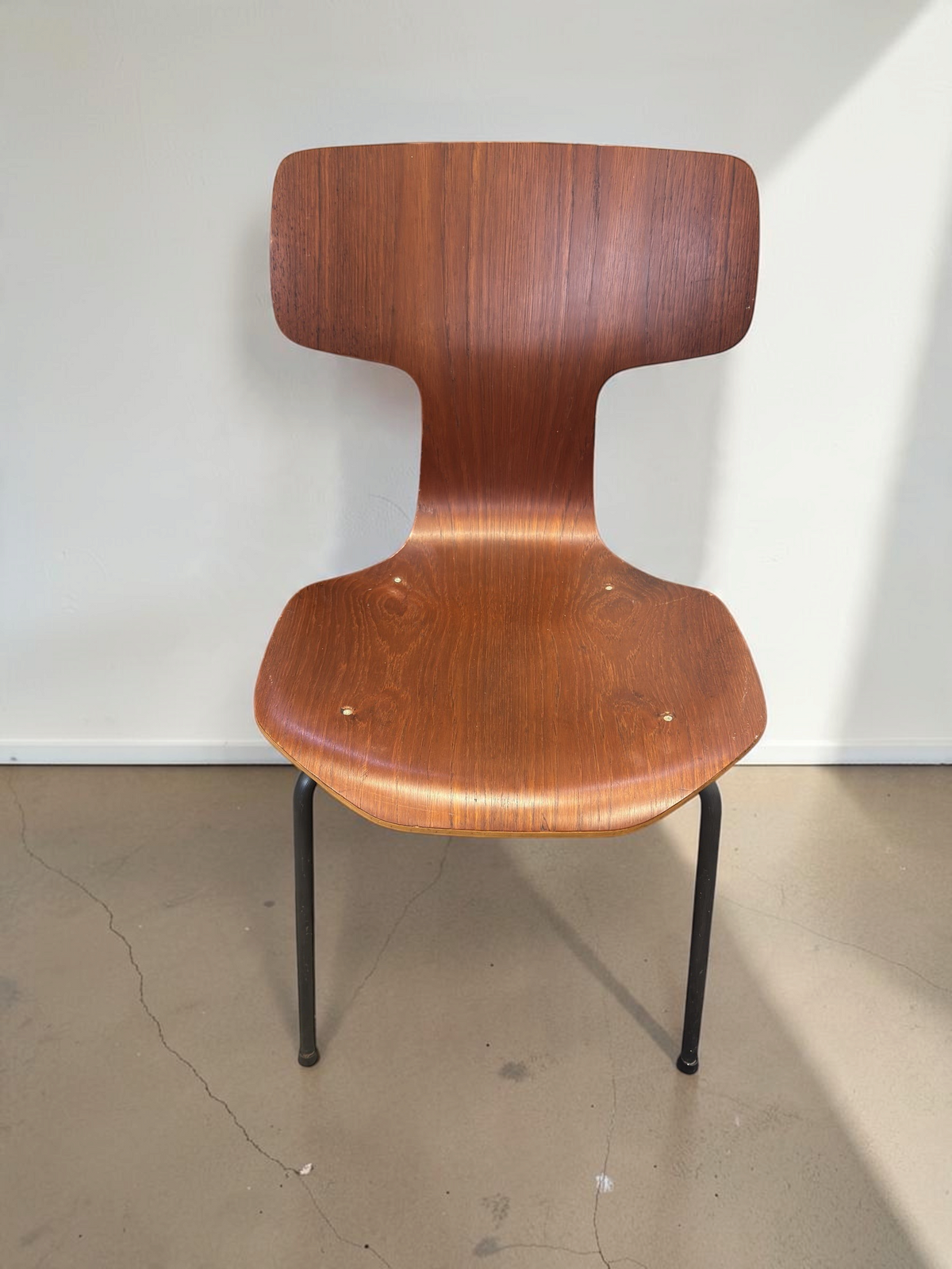tessvintage Arne Jacobsen model 3103 T-stoel van teakfineer met zwarte metalen poten in een vintage interieur