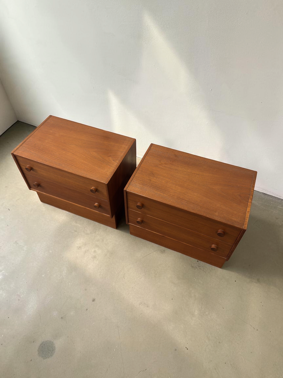 Set van twee tessvintage Deense mid-century nachtkastjes van teakhout met twee lades en ronde handgrepen.
