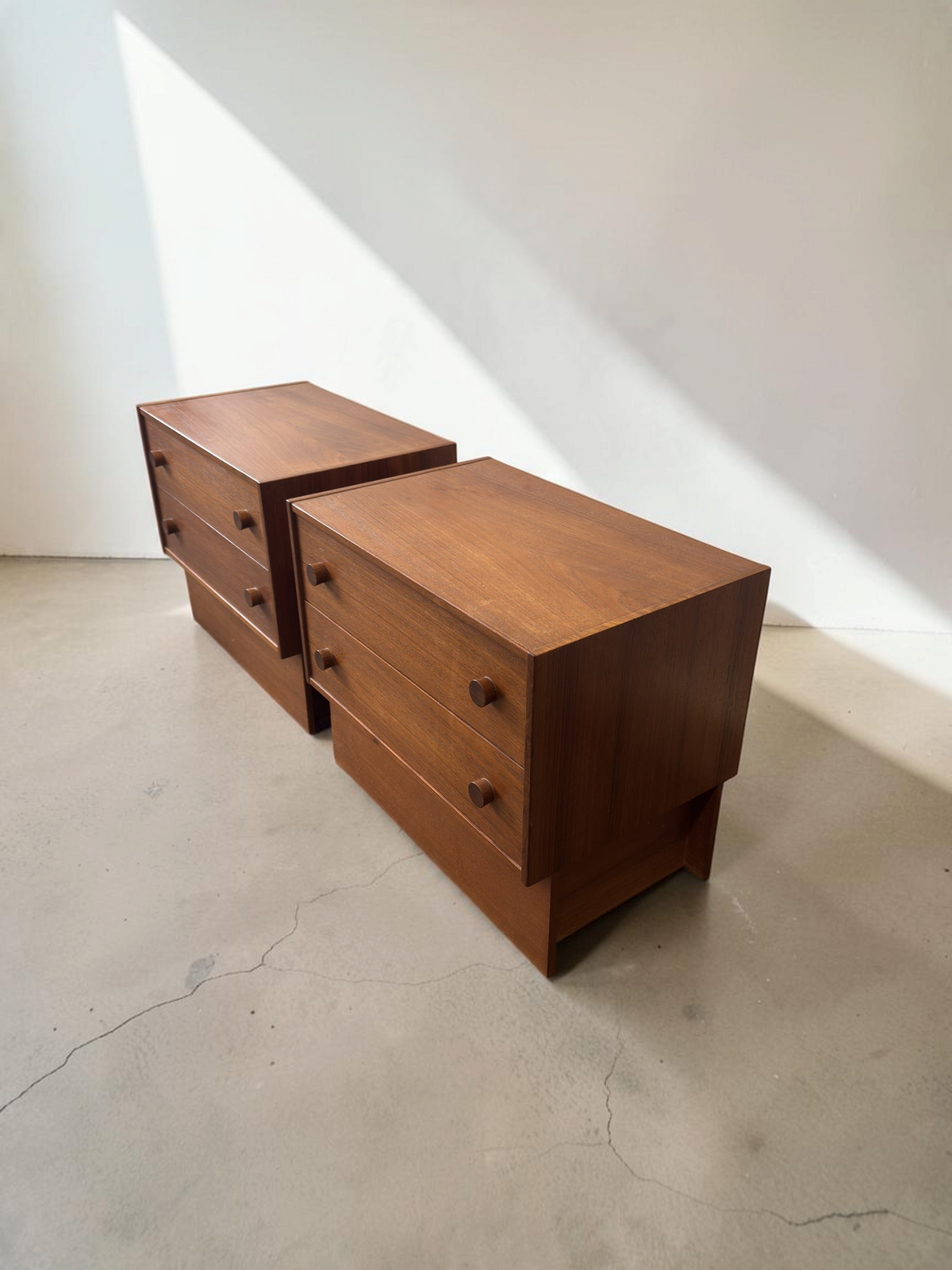 Set van twee tessvintage Deense mid-century nachtkastjes van teakhout met lades en ronde handgrepen.