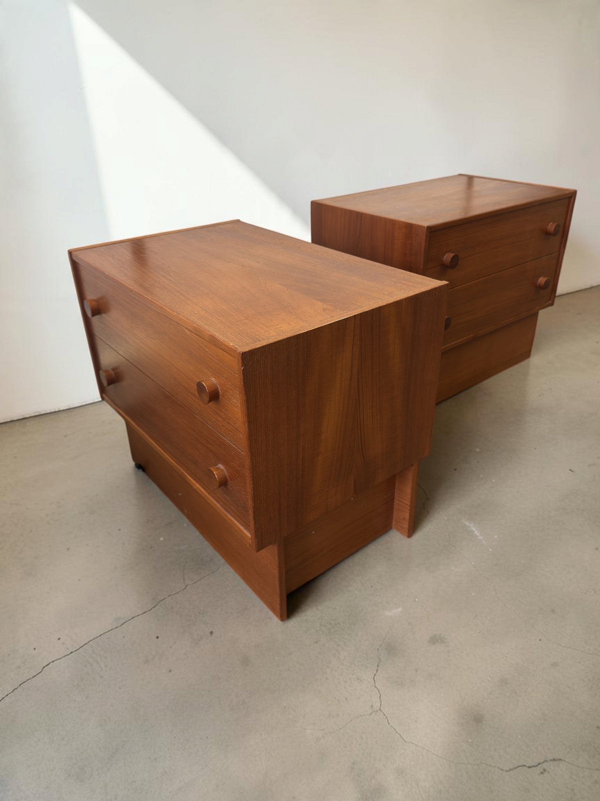 Set van twee tessvintage Deense mid-century nachtkastjes van teakhout met twee lades en ronde handgrepen.
