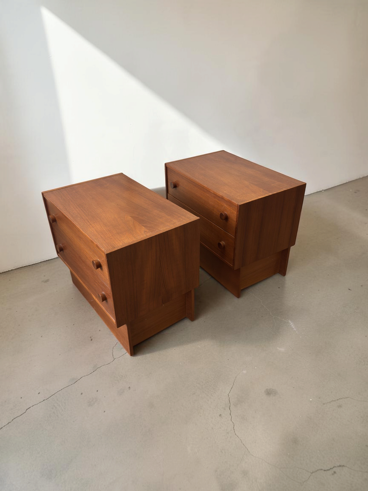 Set van twee tessvintage Deense mid-century nachtkastjes van warm teakhout met lades en minimalistisch kubusframe.