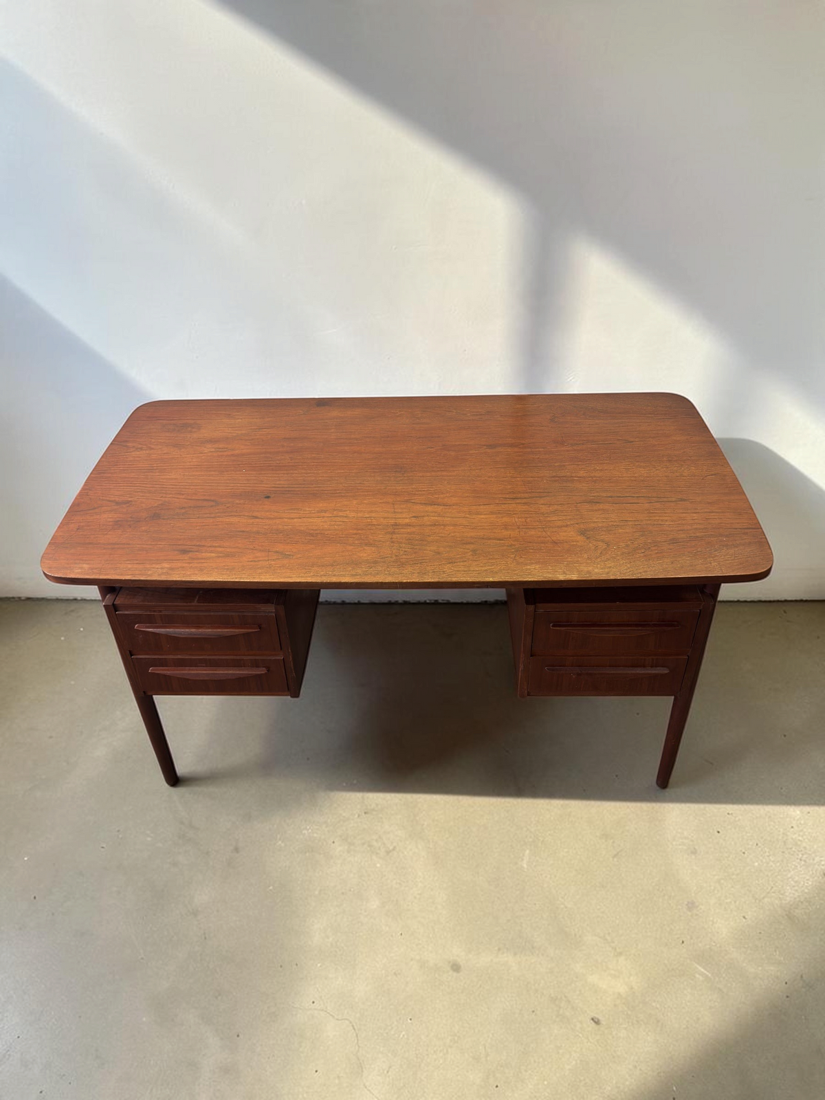 tessvintage Deens teak bureau uit de jaren 60 met vier laden en conische poten in een strak mid-century design