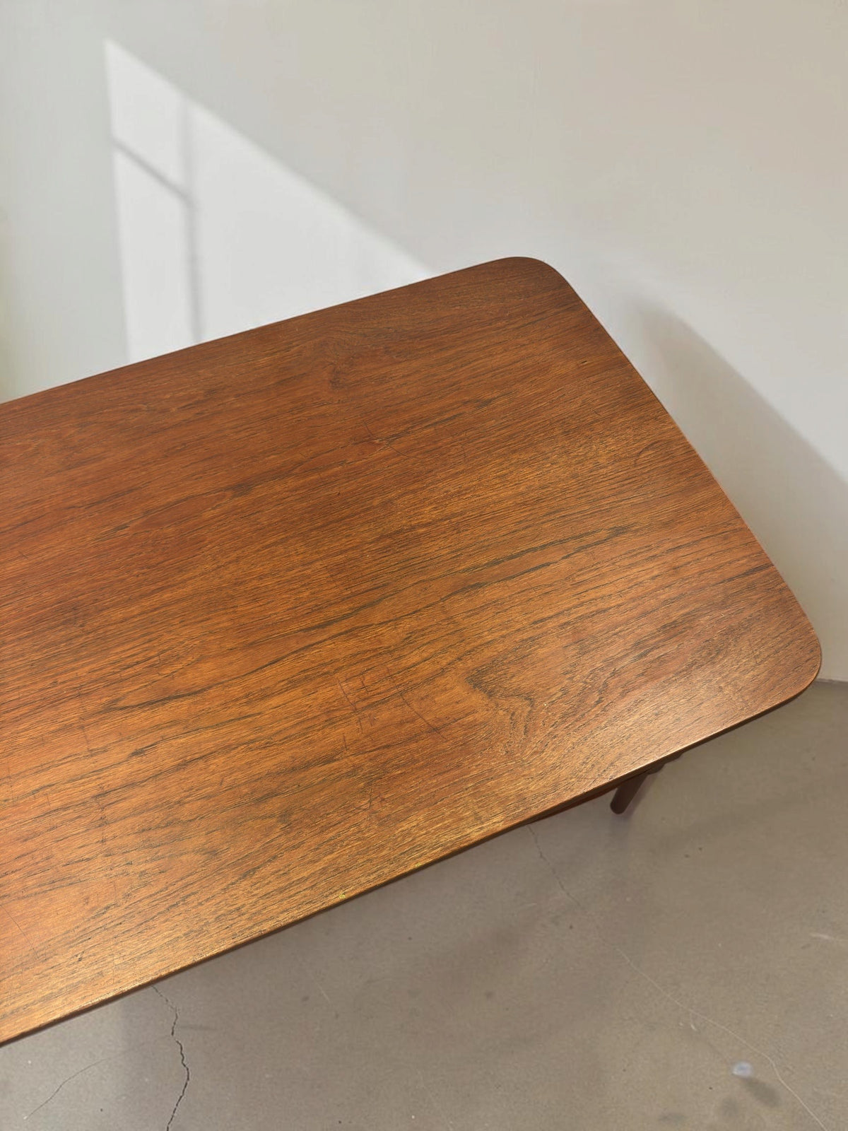 tessvintage Deens teak bureau van Gunnar Nielsen Tibergaard met zichtbaar houtnerf patroon en afgeronde hoeken