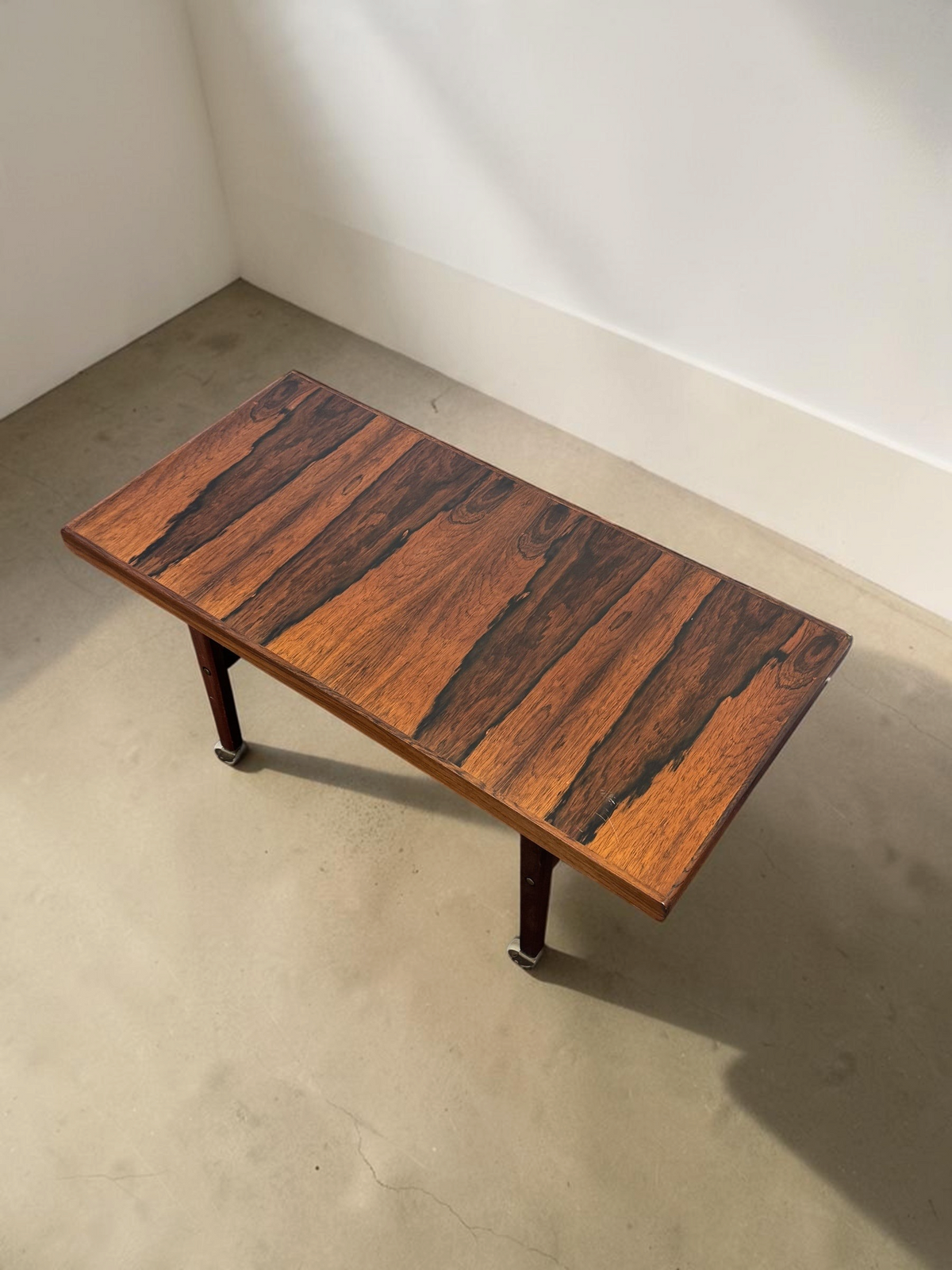 tessvintage Scandinavische salontafel van pallisanderhout met uitschuifbaar blad, rotan lectuurrek en messing wieltjes