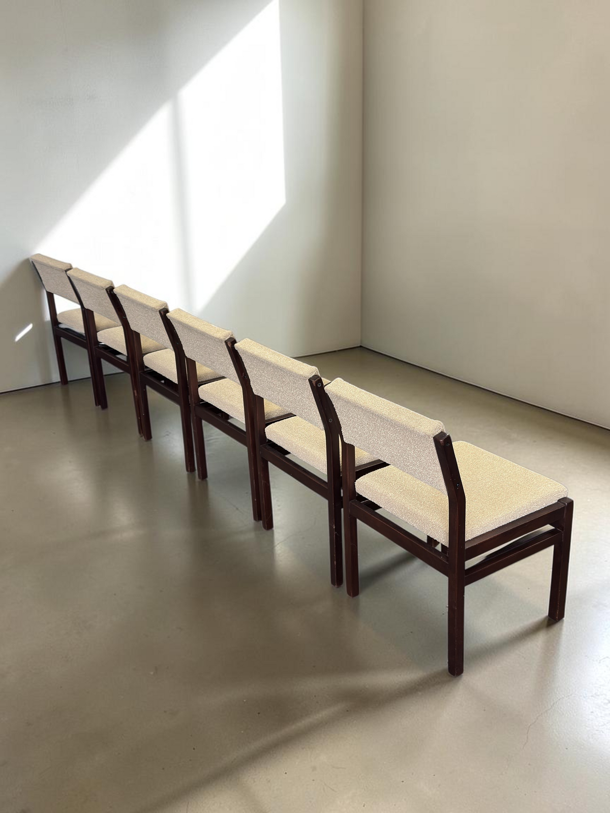 tessvintage set van zes vintage Pastoe stoelen met donkerhouten frame en beige bouclé bekleding in een lichte ruimte