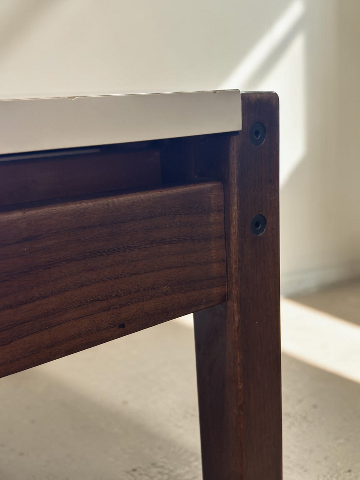 Detail van het wenge houten frame en wit formica blad van de vintage Pastoe TU31 tafel van tessvintage