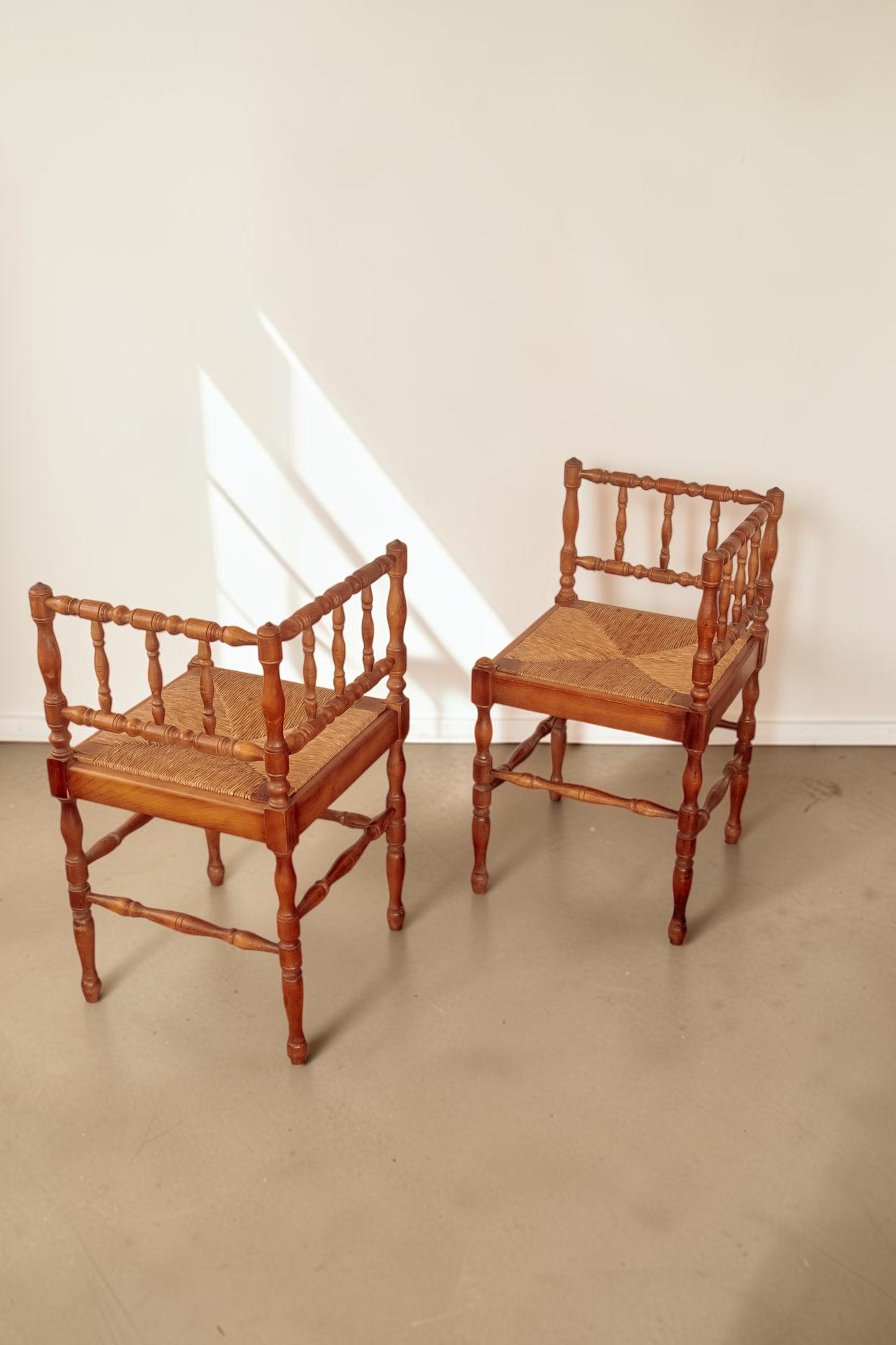 Set van 2 antieke Franse tessvintage hoekstoelen met gedraaide bobbin spijlen en een gevlochten biezen zitting.