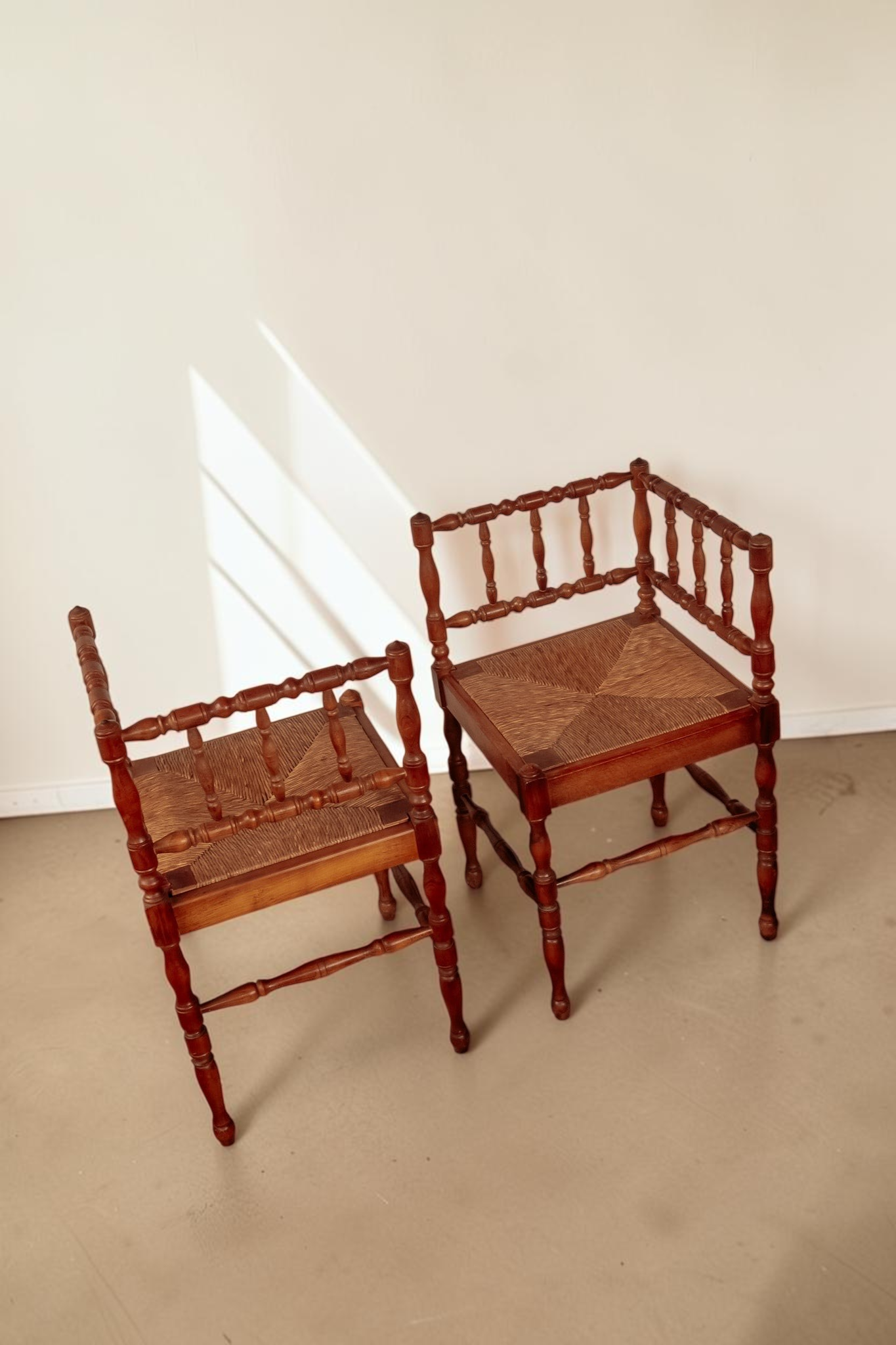 Set van twee antieke Franse tessvintage hoekstoelen met gedraaide houten spijlen en een gevlochten biezen zitting.