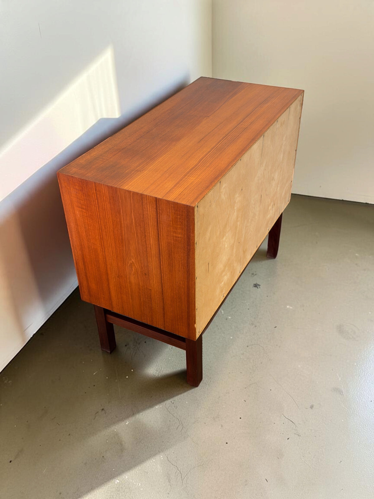 tessvintage Deens teak dressoir met schuifdeuren en donker houten H-frame onderstel, achteraanzicht