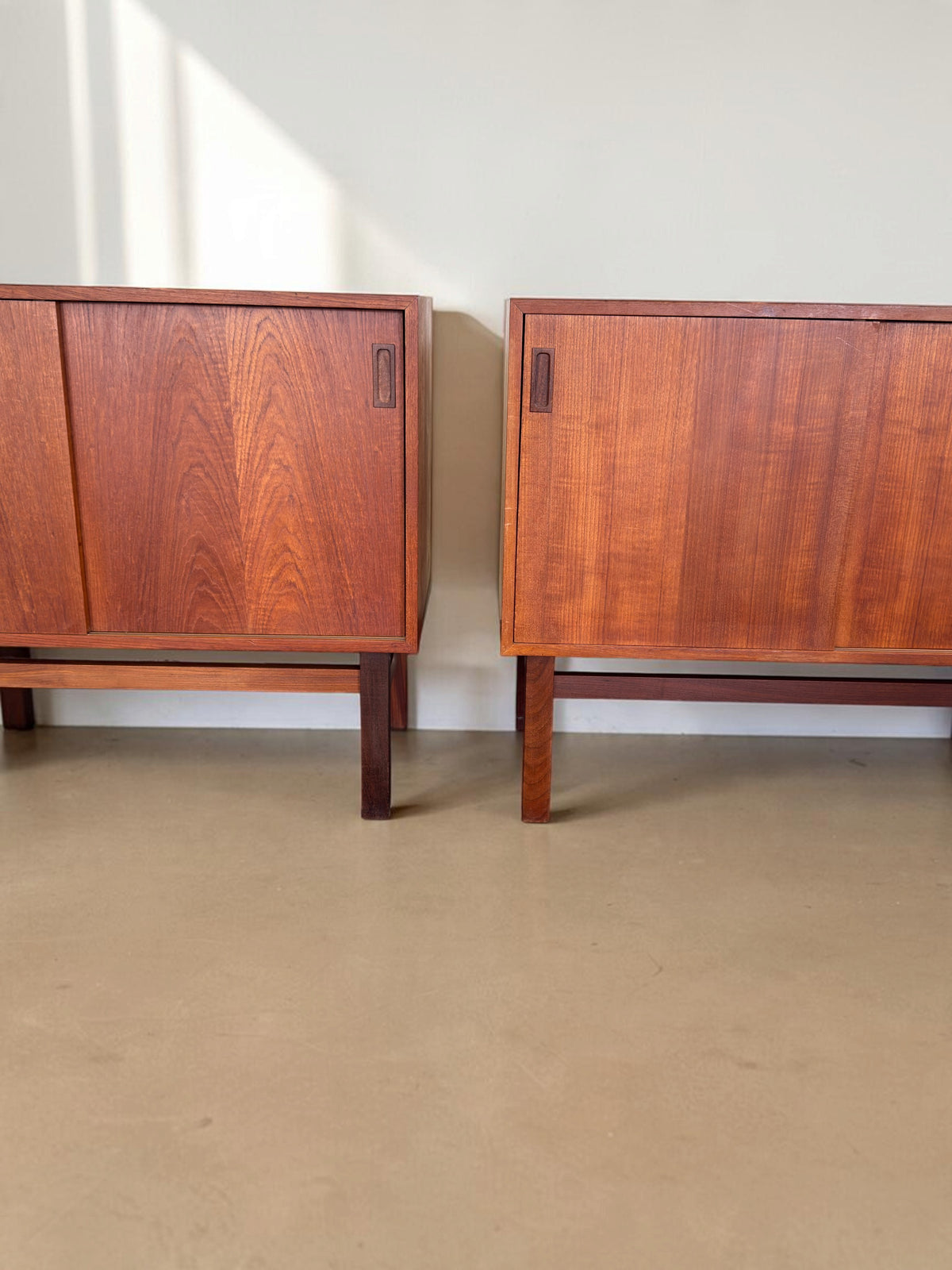 tessvintage Deens teak dressoir met schuifdeuren en donker houten H-frame onderstel in een strak vintage design