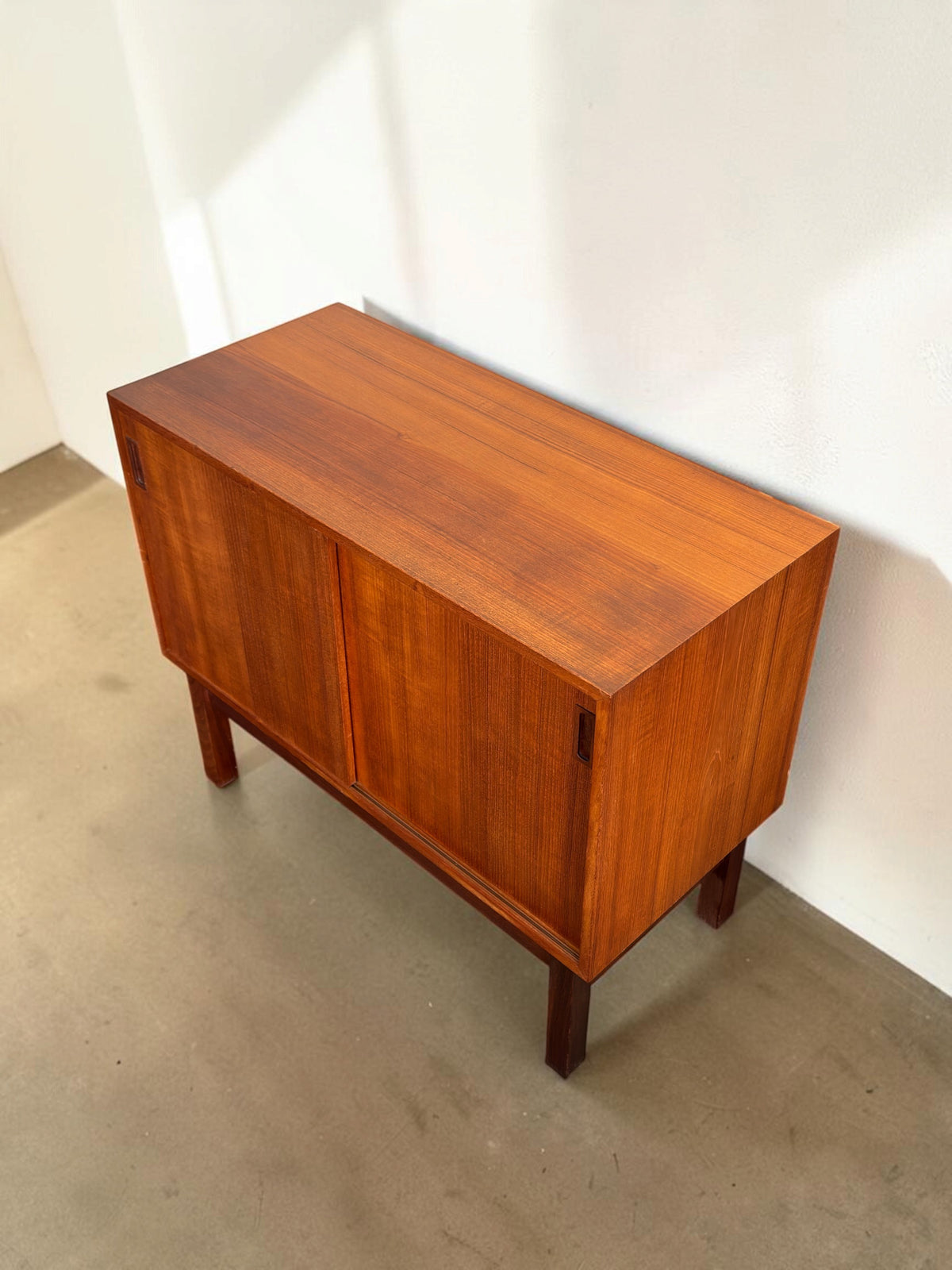 tessvintage Deens teak dressoir met schuifdeuren en donker houten H-frame onderstel in een strak vintage design