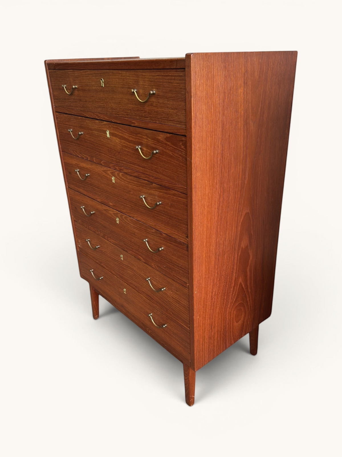 tessvintage Deense tallboy ladekast van teakhout met zes lades, messing greepjes en tapse pootjes uit de jaren 60.