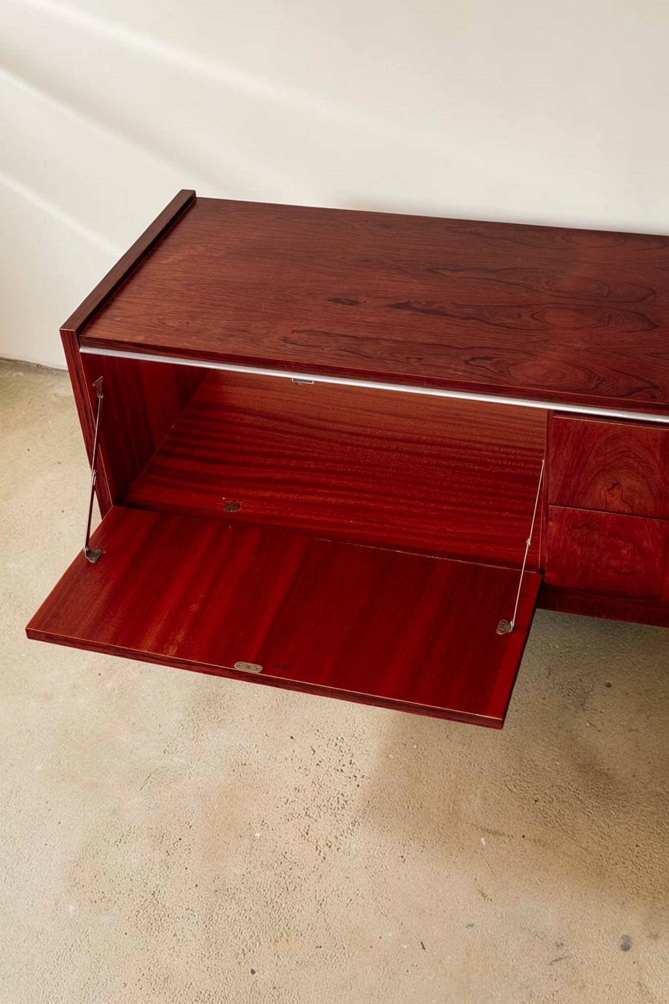 tessvintage 1960s rosewood veneer sideboard with open drop-down door and visible wood grain texture