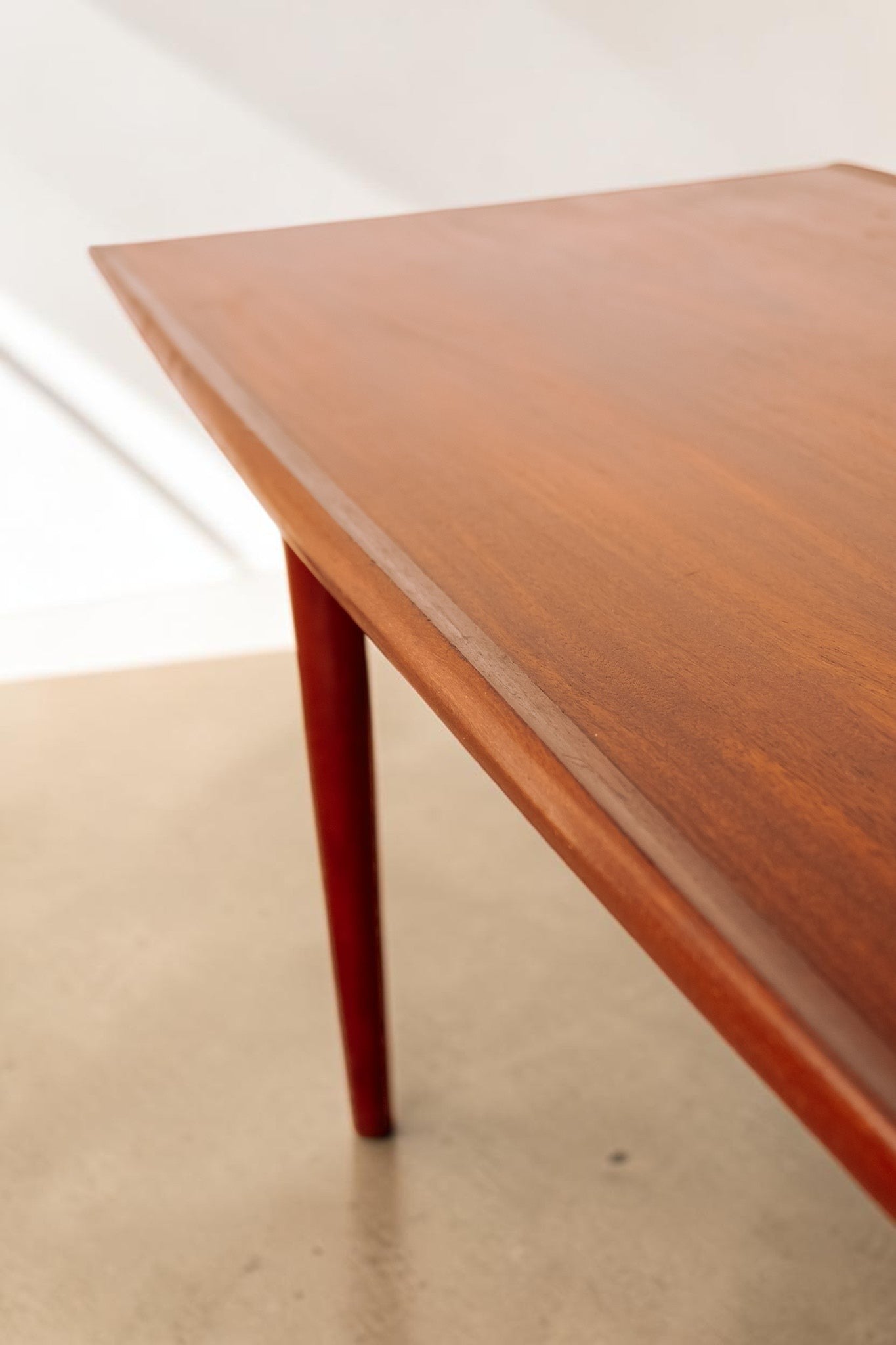 tessvintage mid century modern teak coffee table with rounded edges and tapered legs, showing rich wood grain