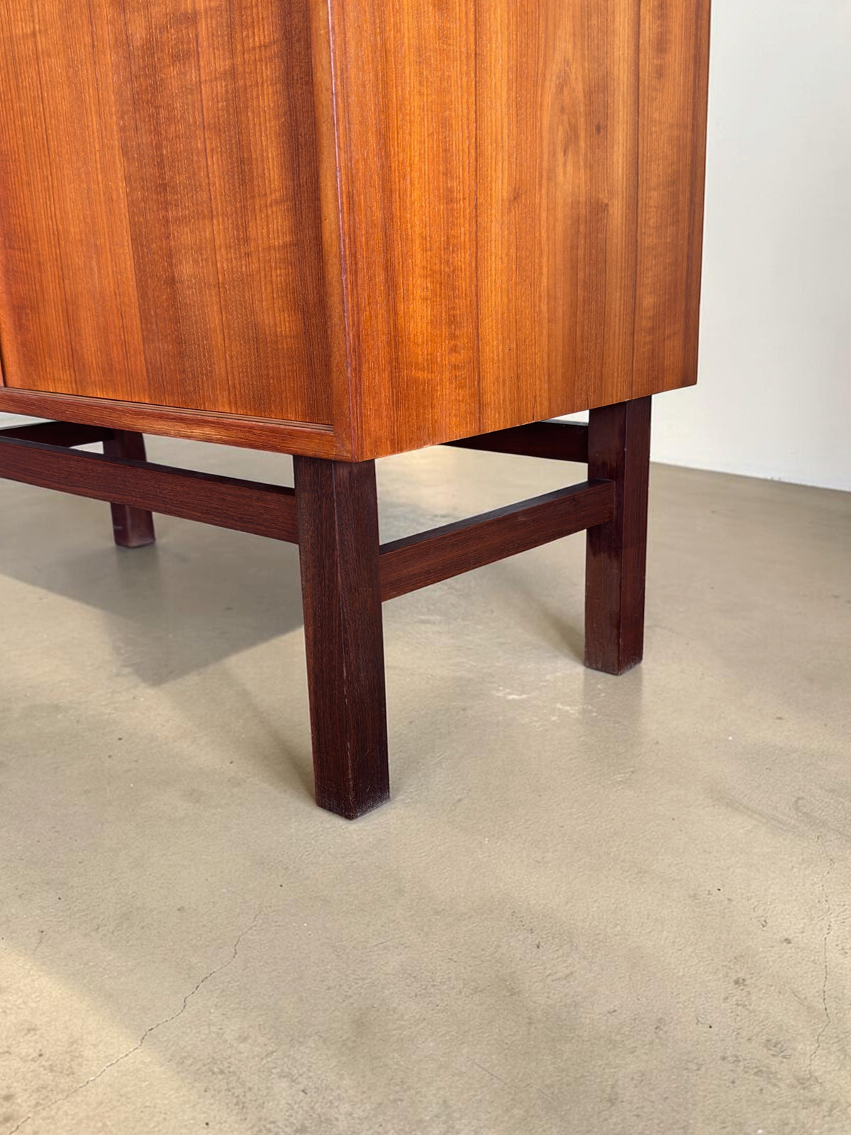 tessvintage Deens teak dressoir met donkerhouten H-frame onderstel en warme houtnerf details