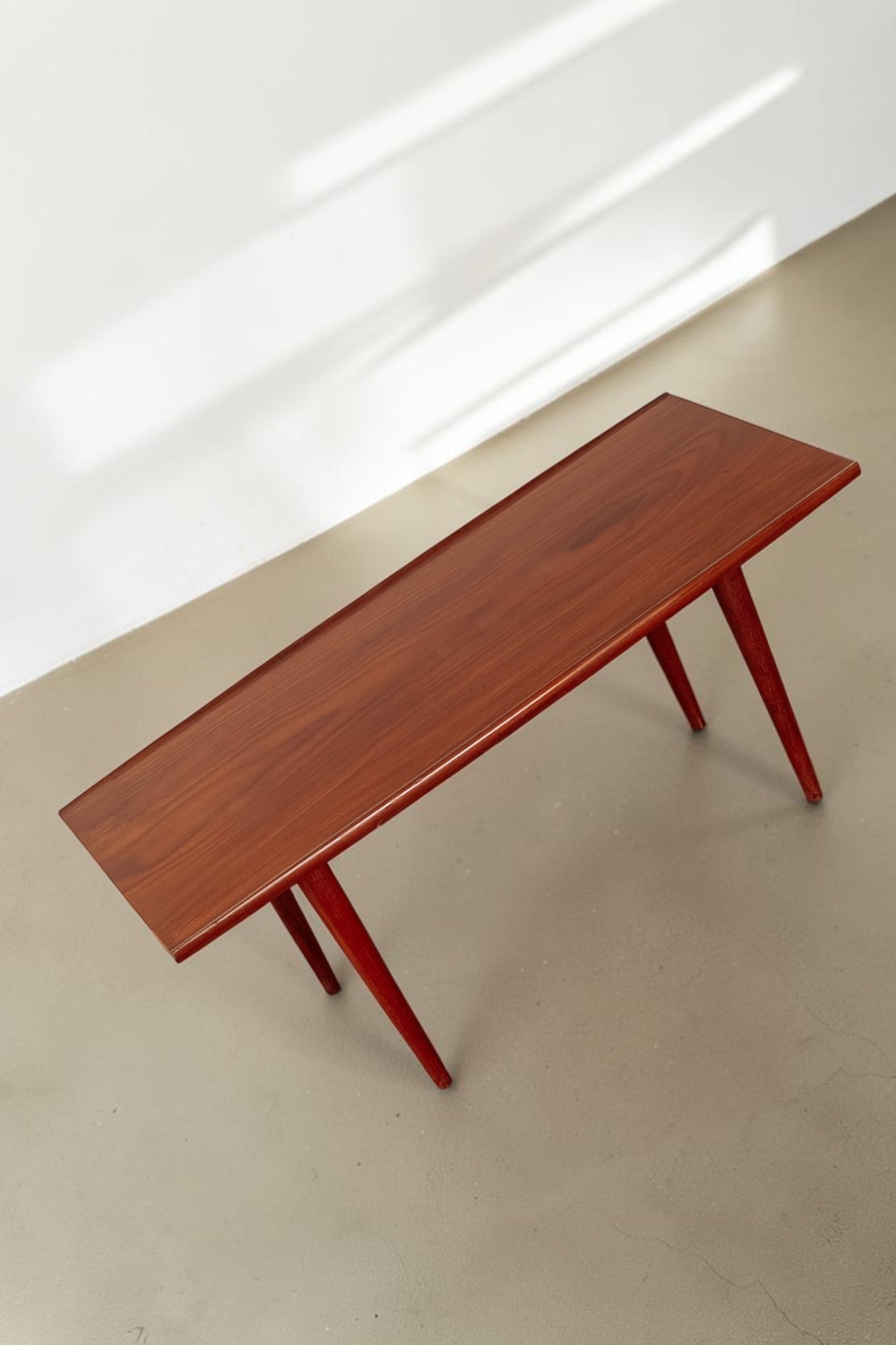 tessvintage mid-century modern teak coffee table with rounded edges and tapered legs in a warm wood finish