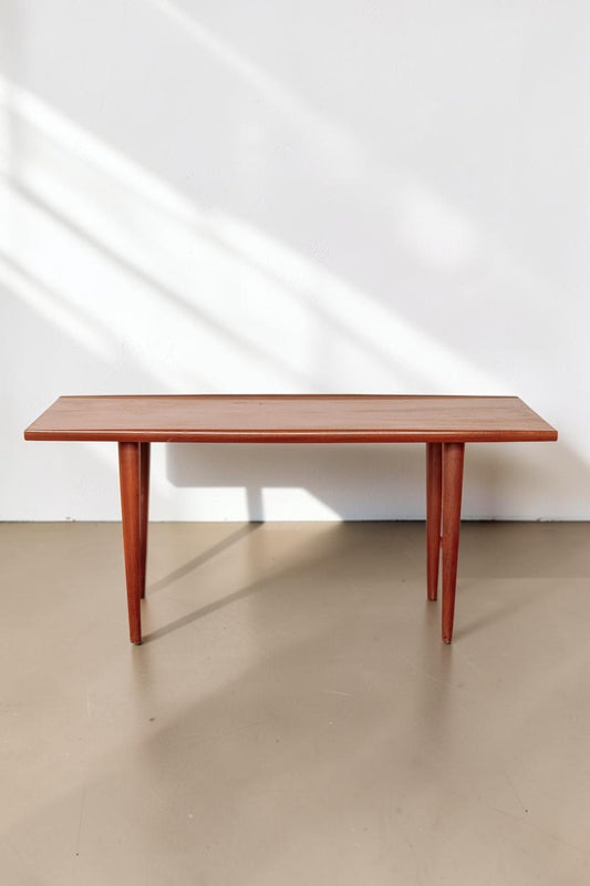 tessvintage mid-century modern teak coffee table with rounded edges and tapered legs in a warm wood finish