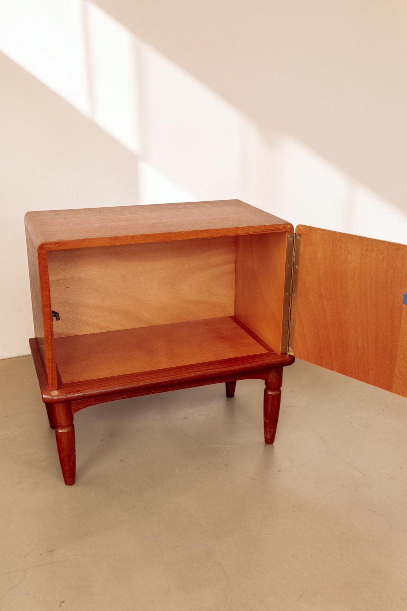 tessvintage teak nachtkastje uit de jaren 60 met open deur en conische poten in een warme houtkleur