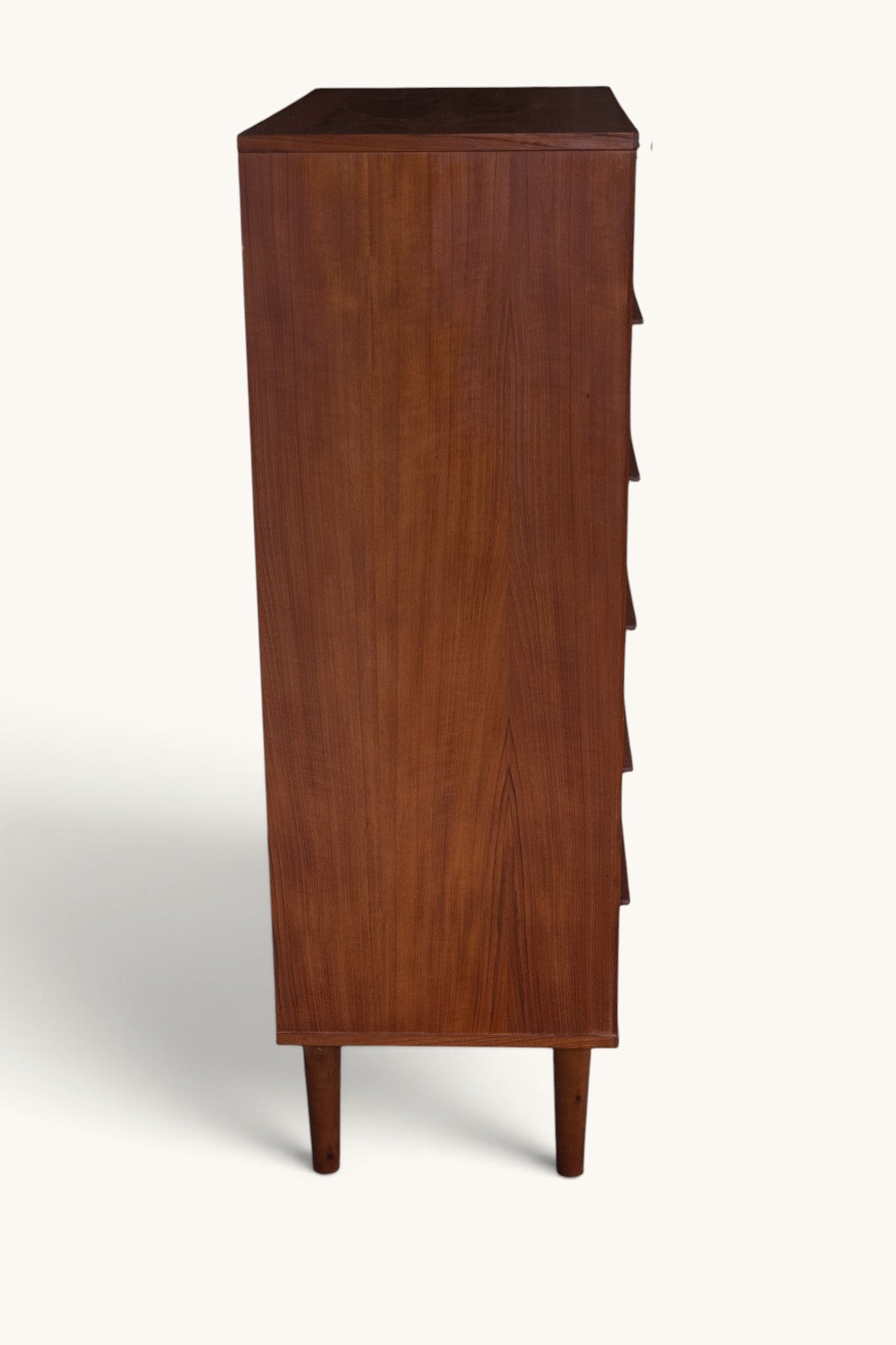tessvintage vintage Danish teak tallboy chest of drawers with seven drawers and carved wooden handles, side view